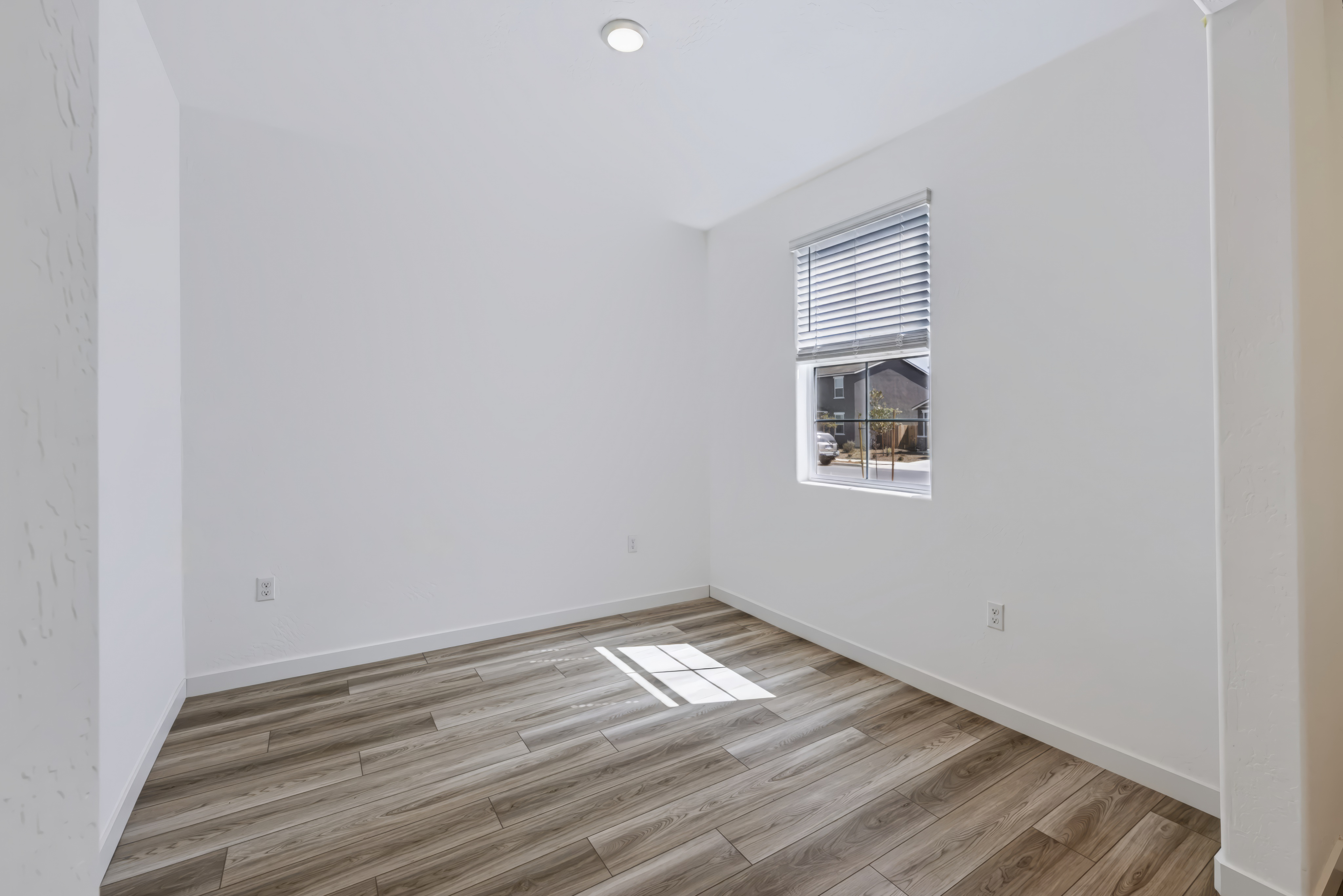 A room with a wood floor and a window.