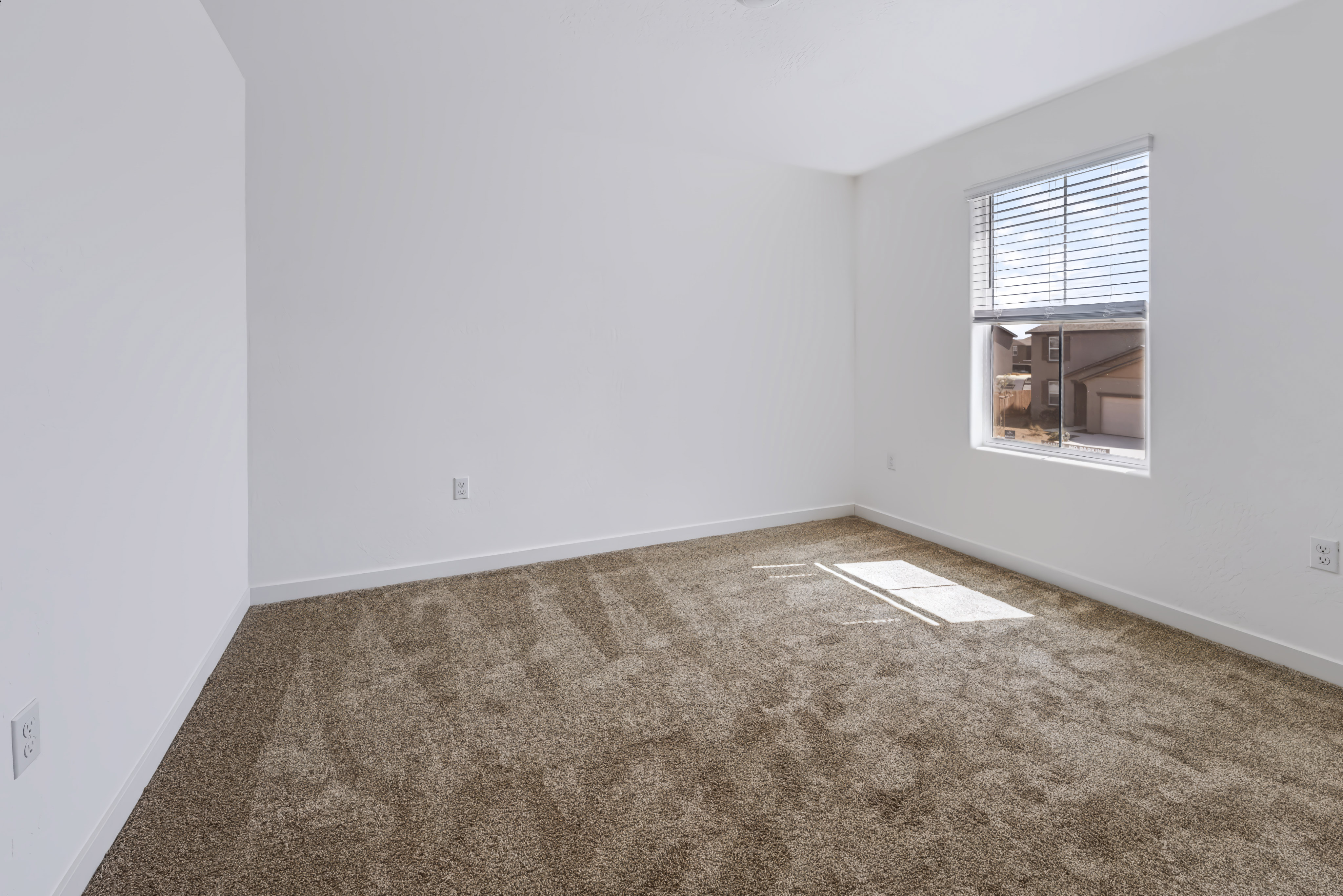 A room with a carpet and a window.