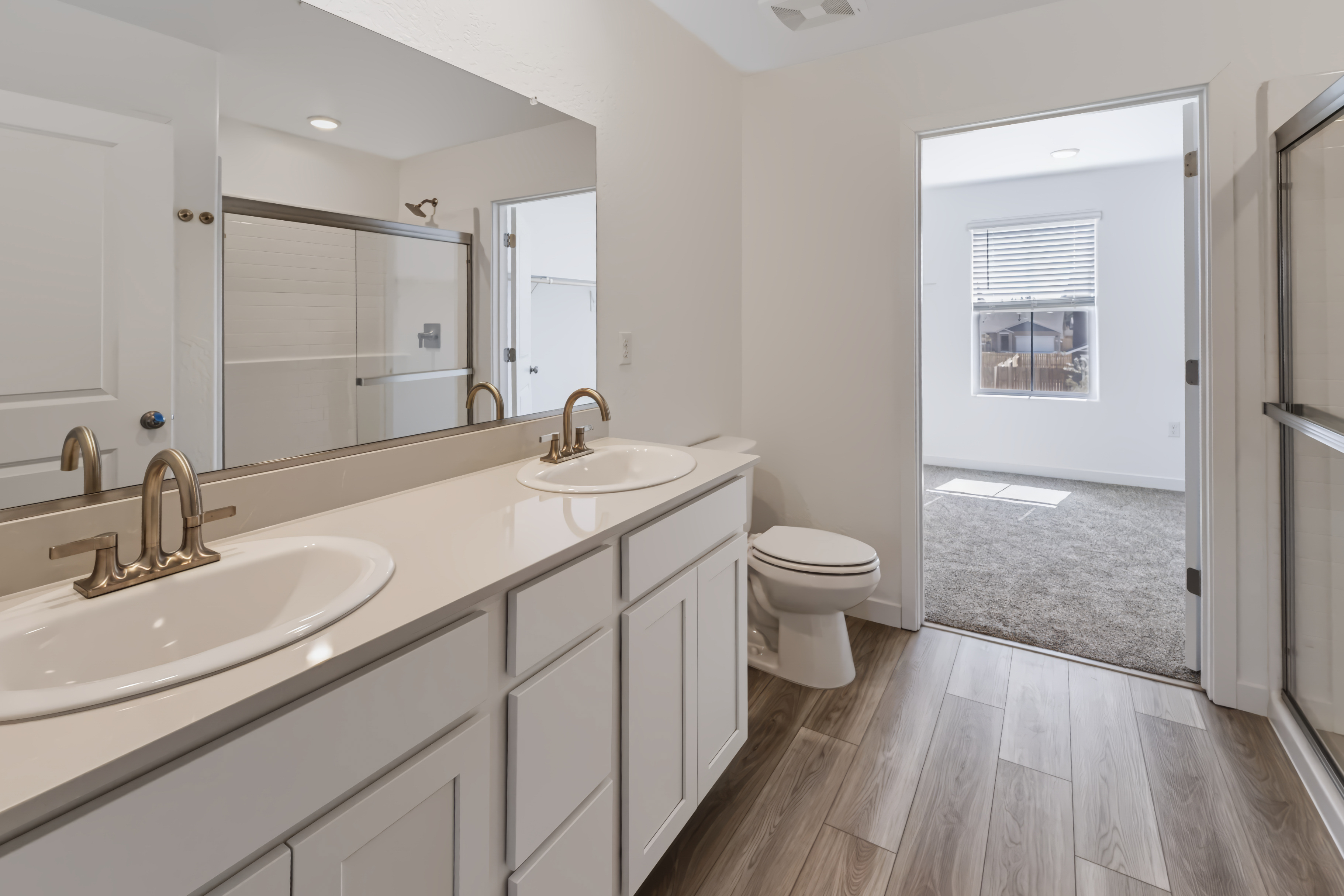 A bathroom with a sink toilet and mirror.