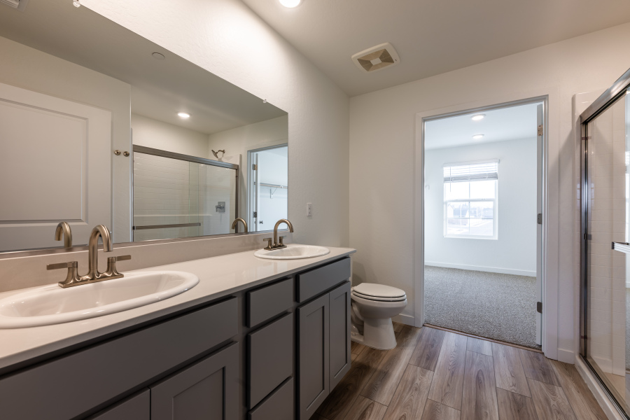 A bathroom with a sink toilet and mirror.
