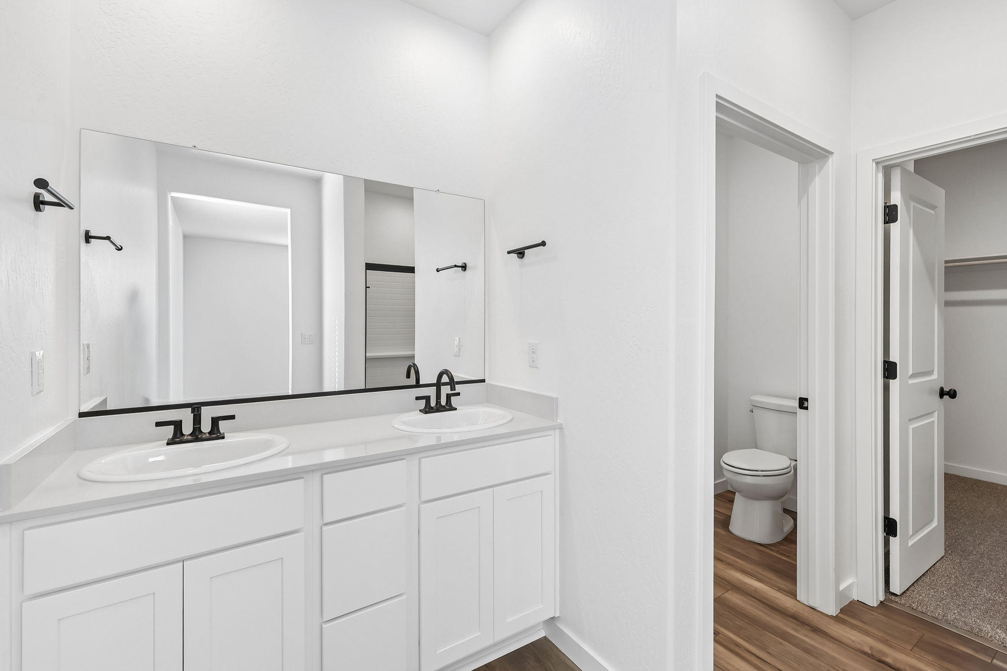 A bathroom with white cabinets.