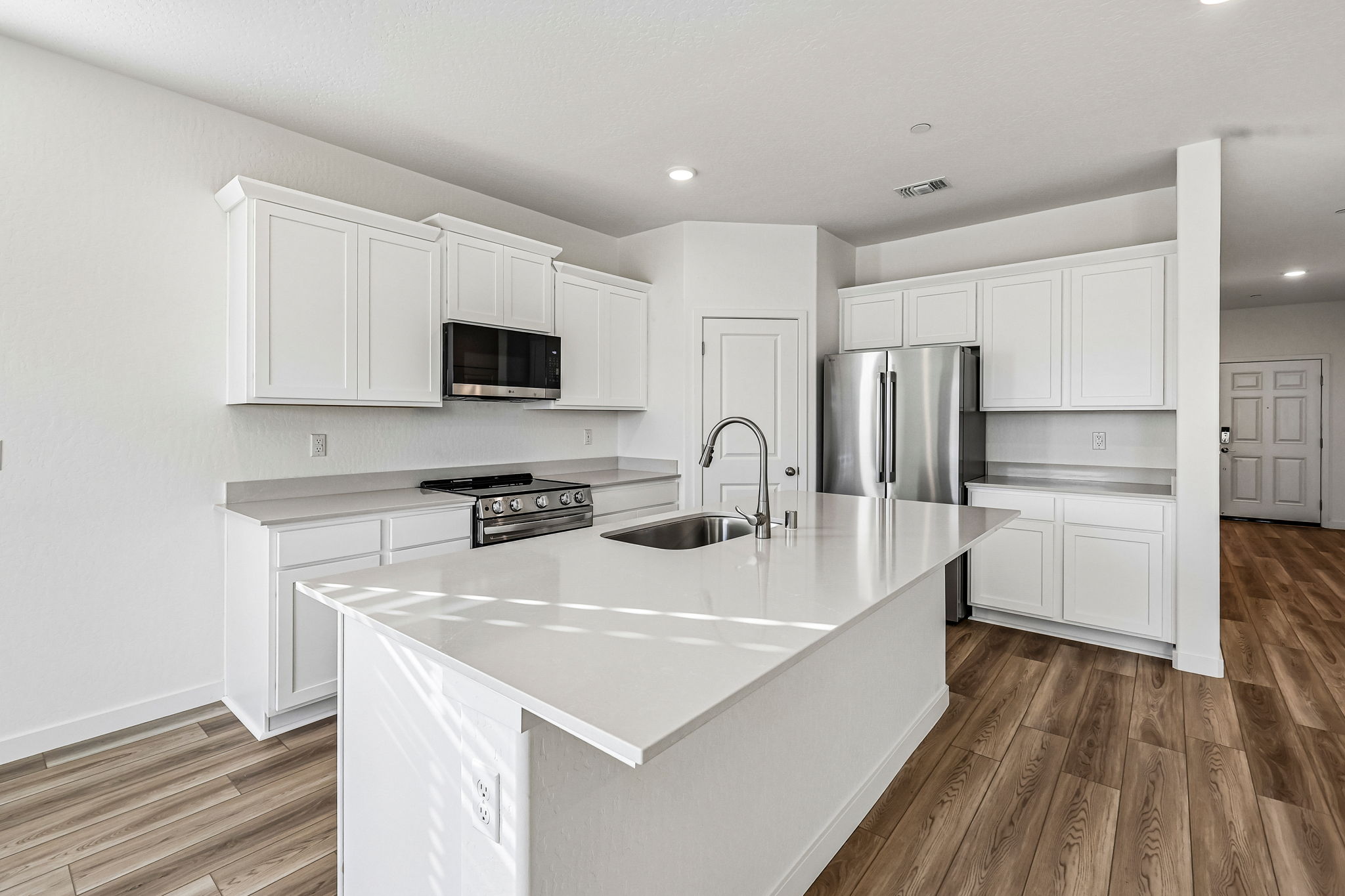 A kitchen with white cabinets.