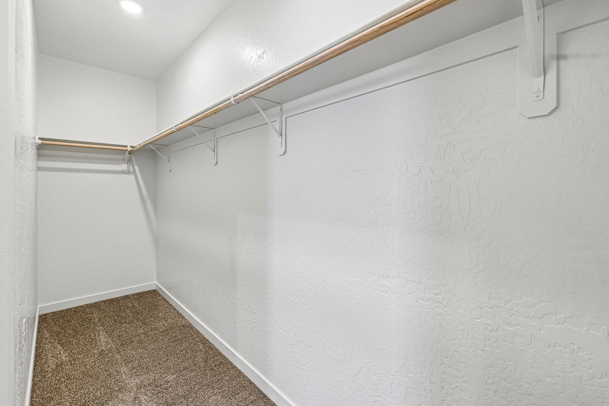 A white wall with a metal bar.