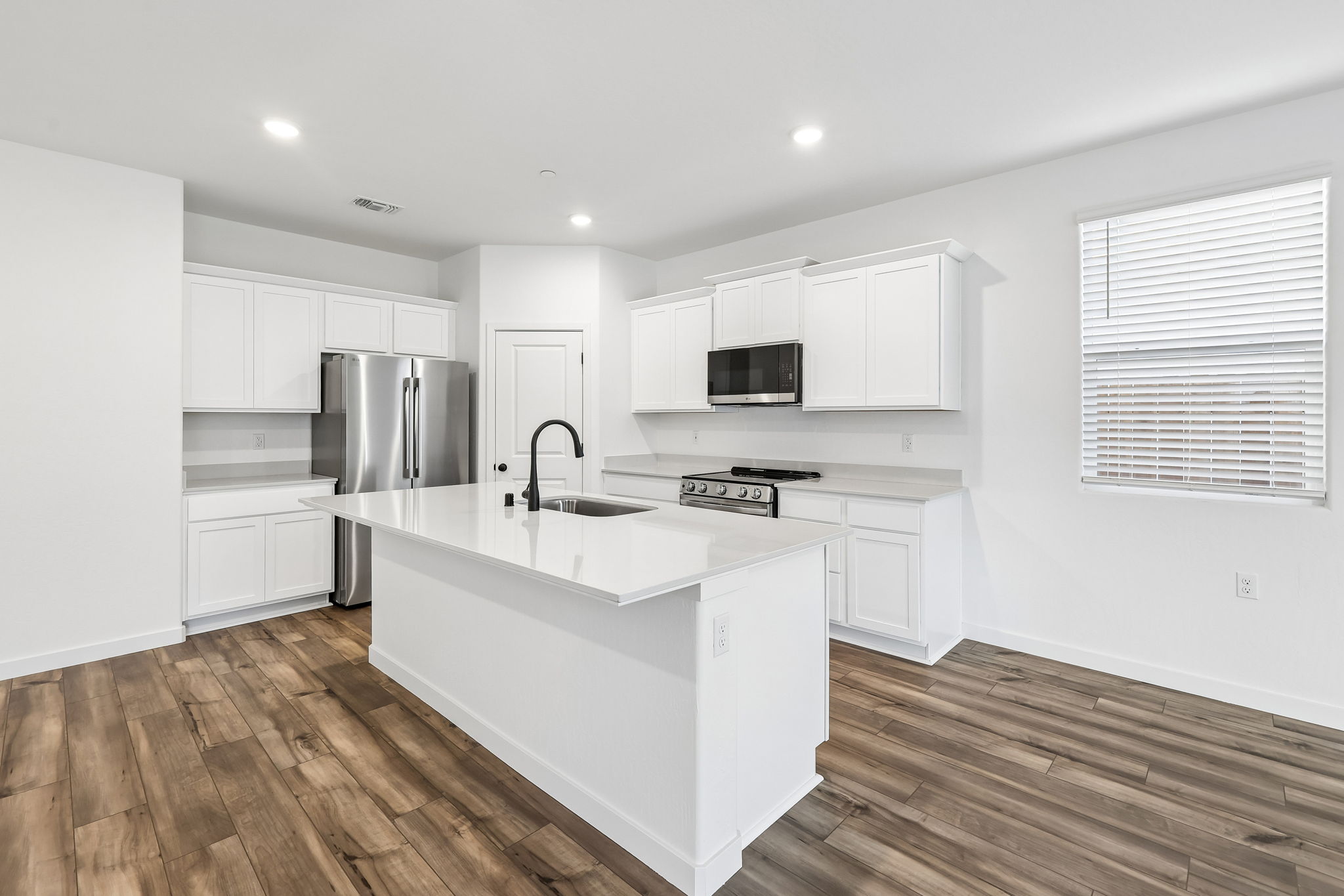 A kitchen with white cabinets.