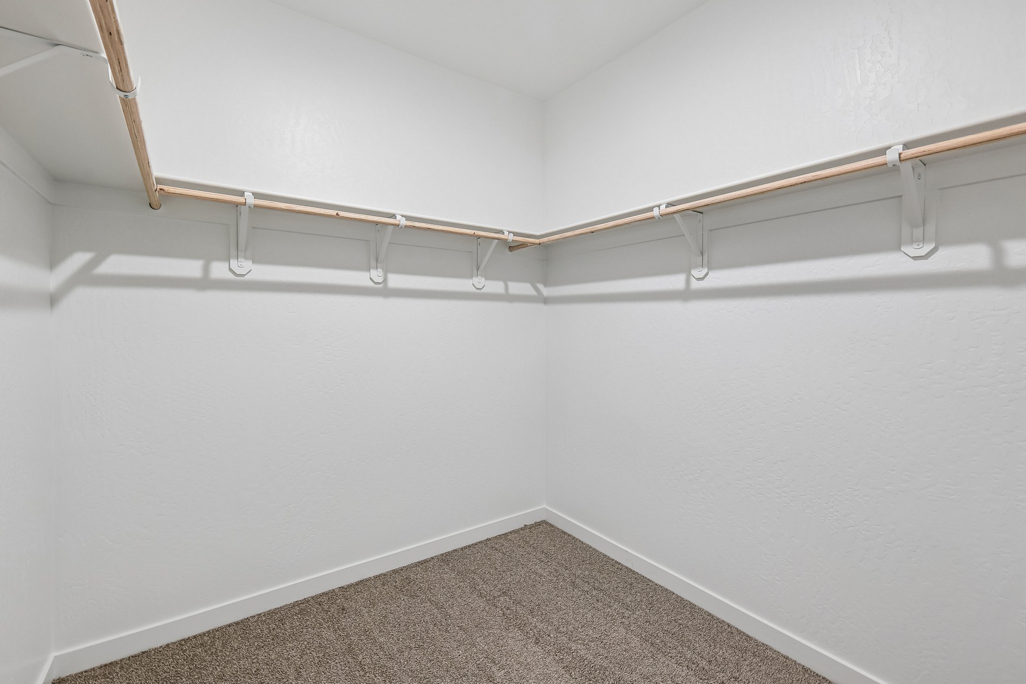 A white wall with a metal bar.