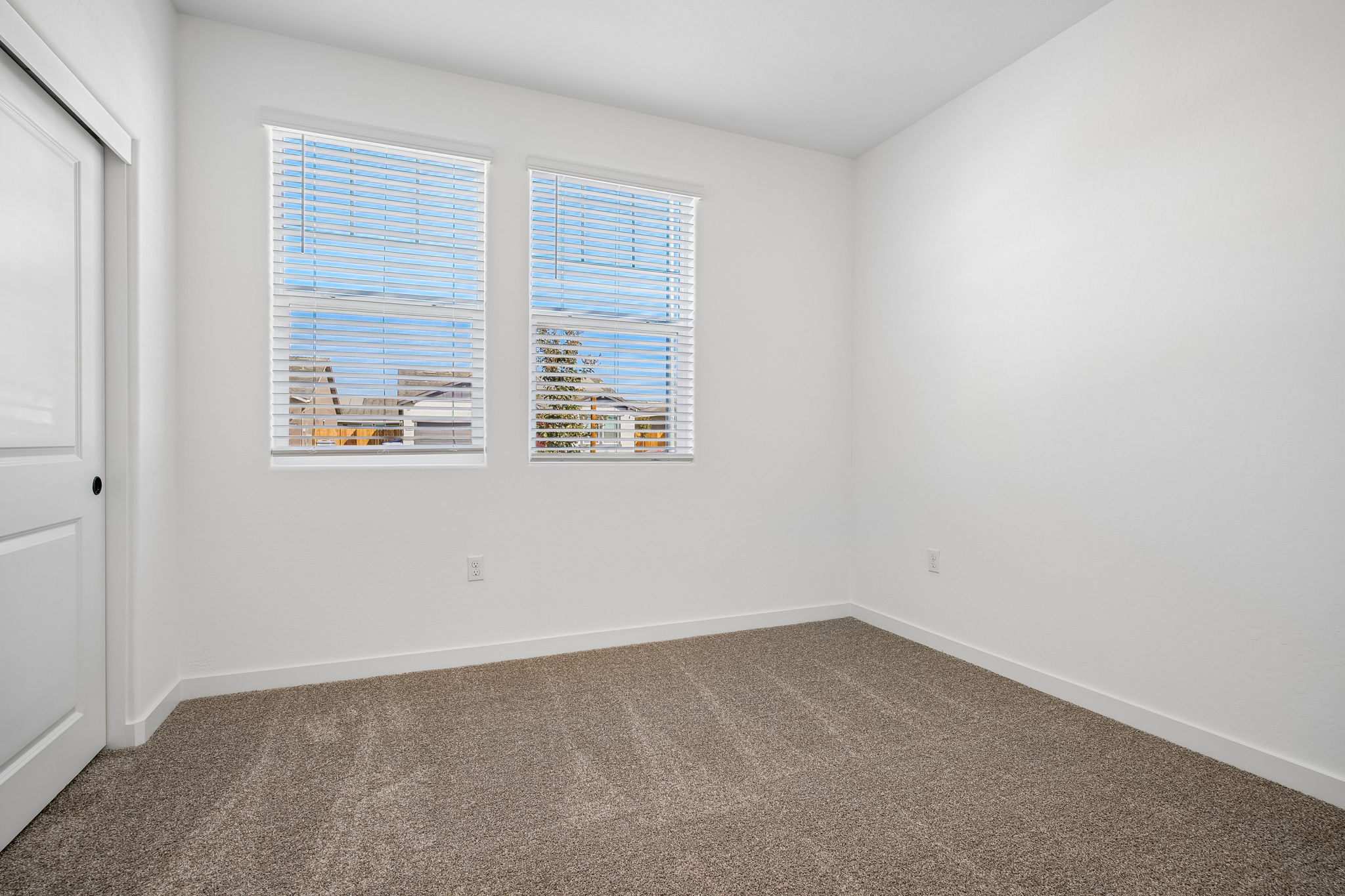 A room with a window and a carpet.