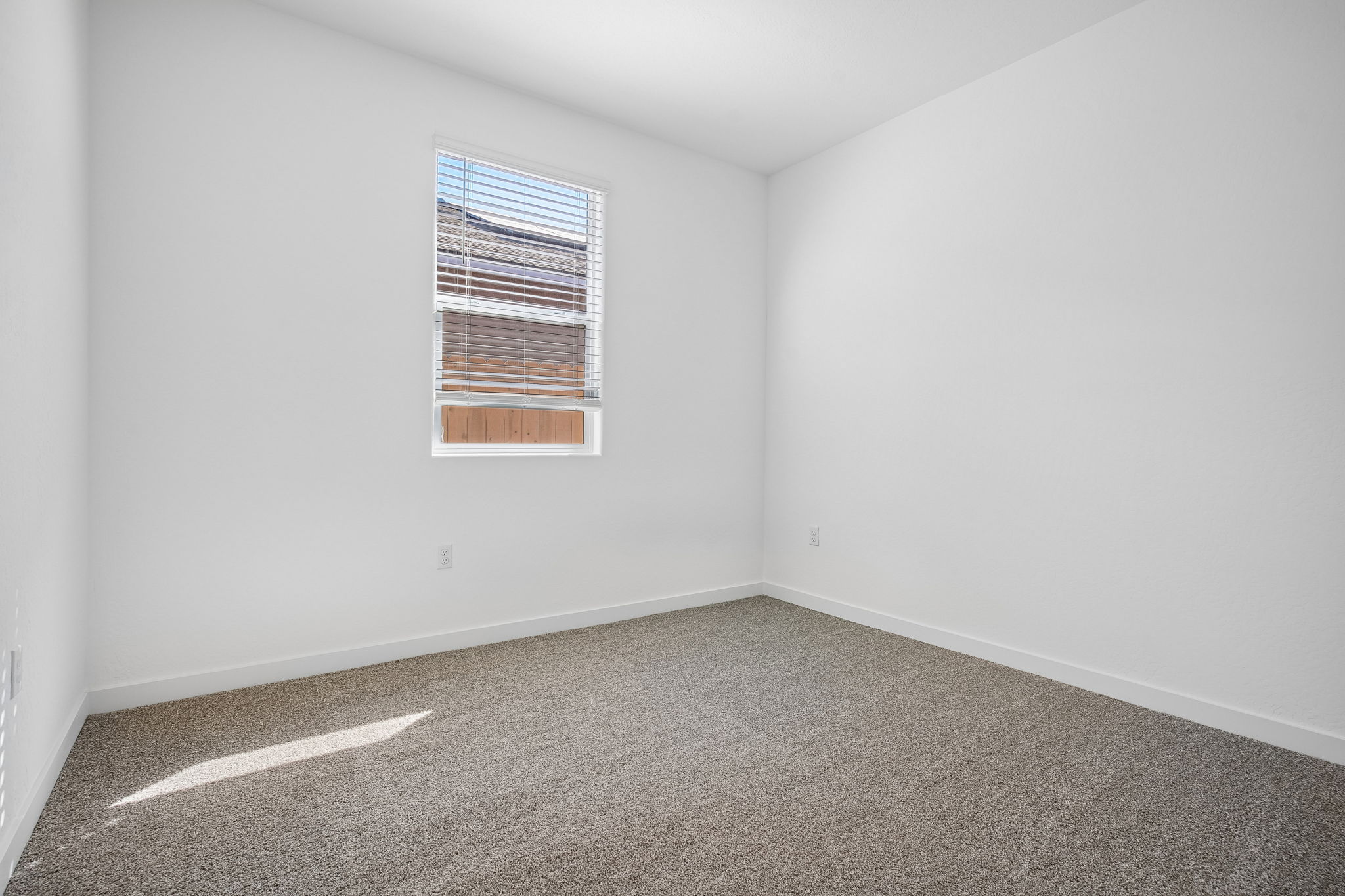 A room with a carpet and a window.