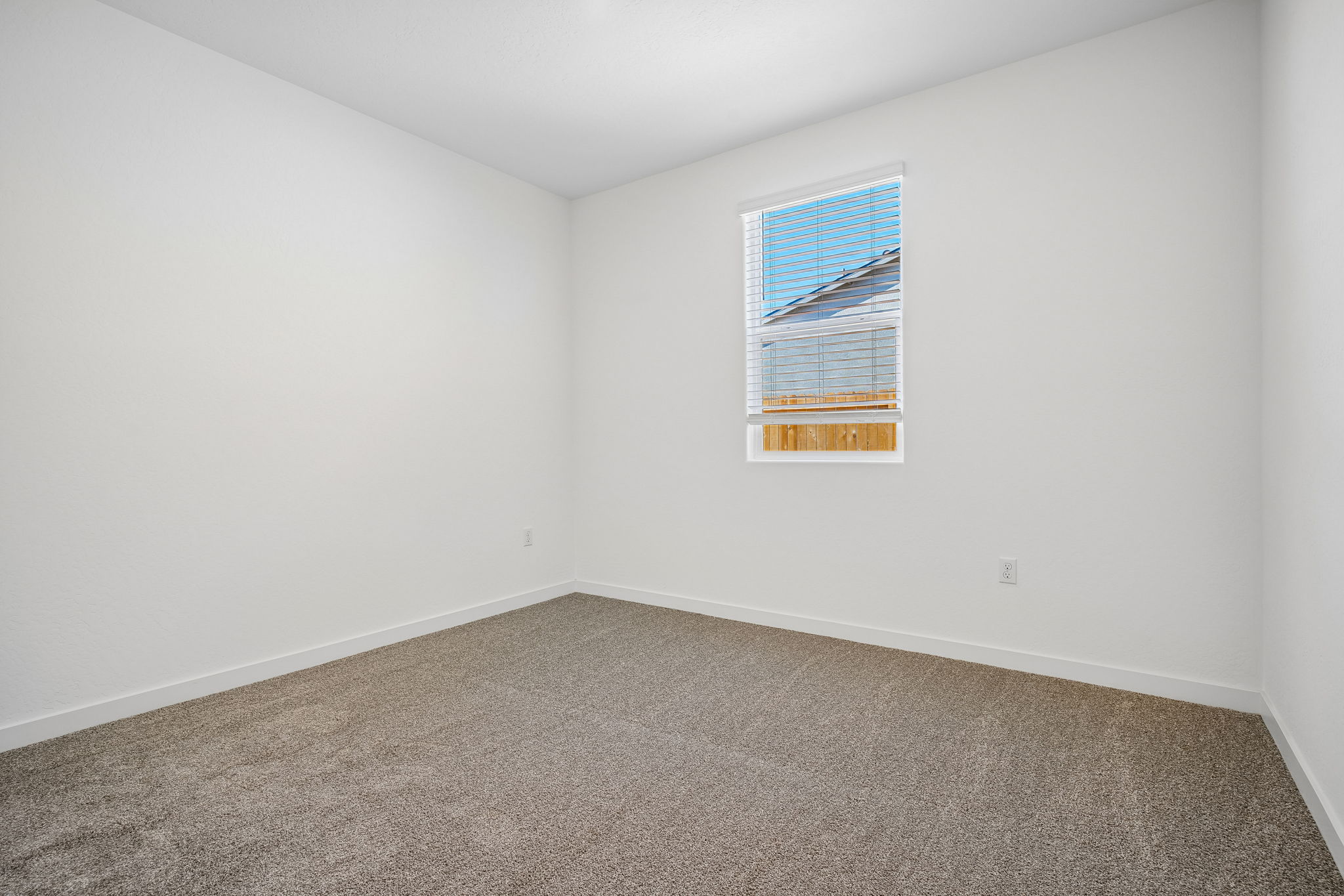 A room with a carpet and a window.