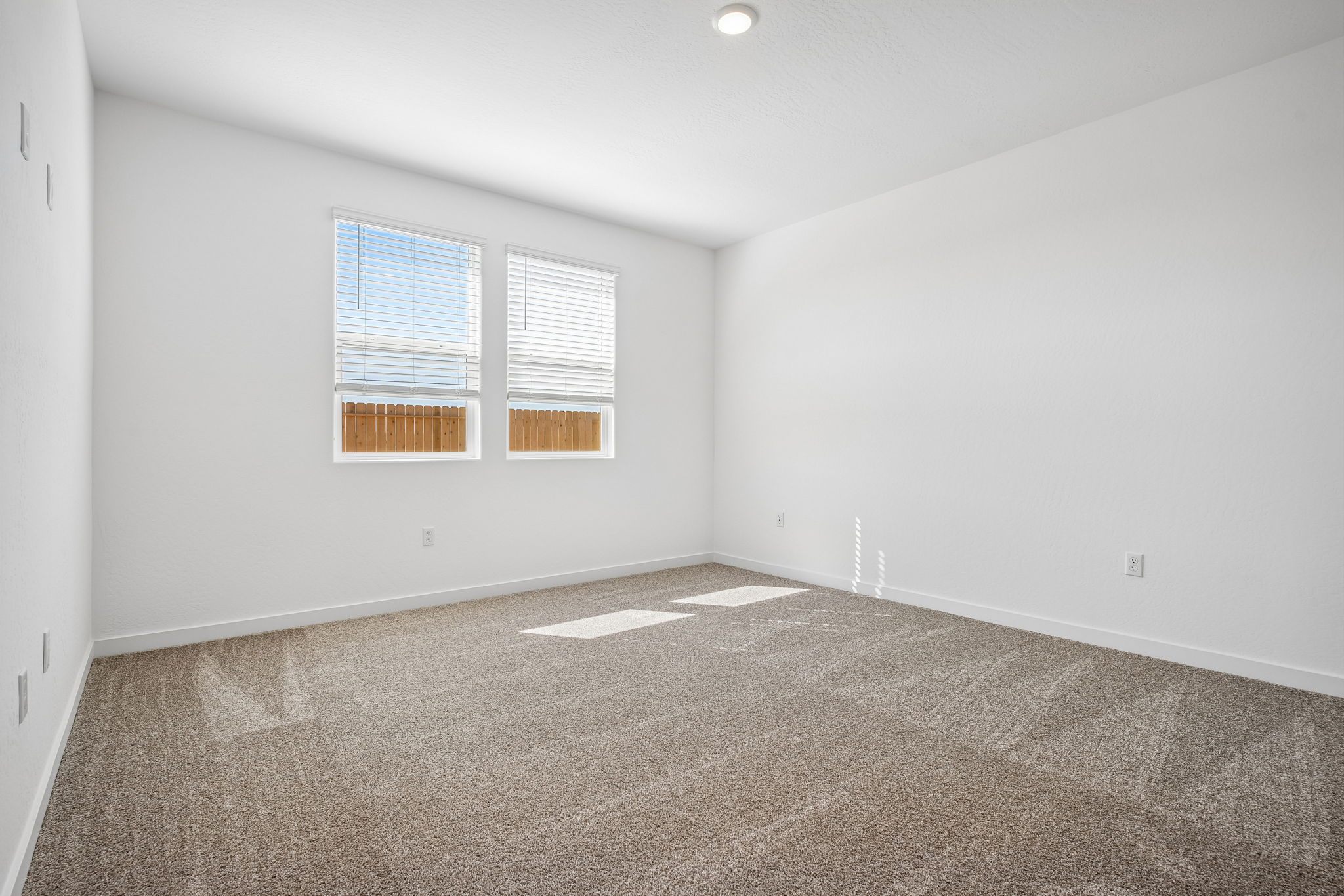A room with a carpet and a window.