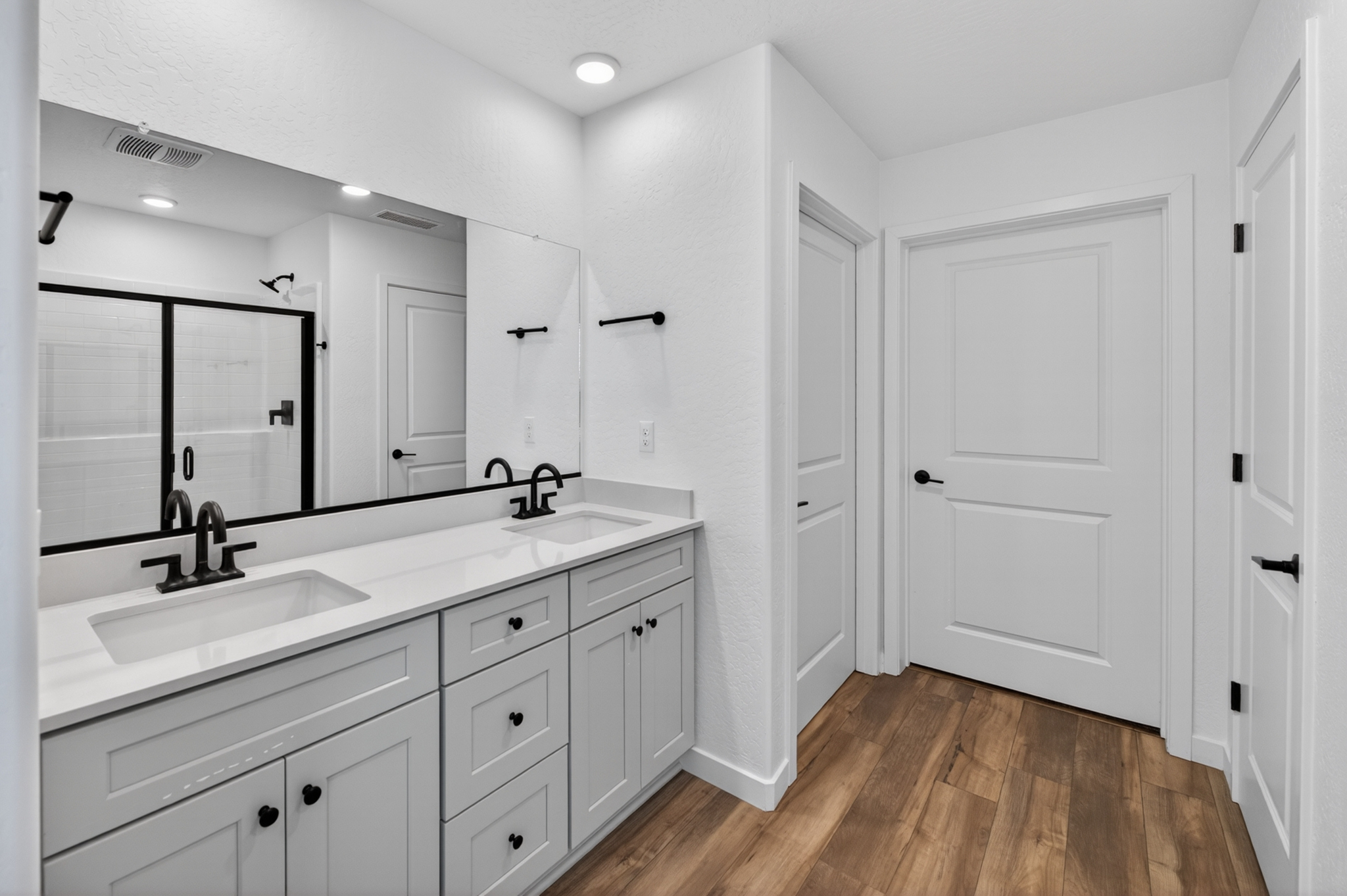 A bathroom with white cabinets.
