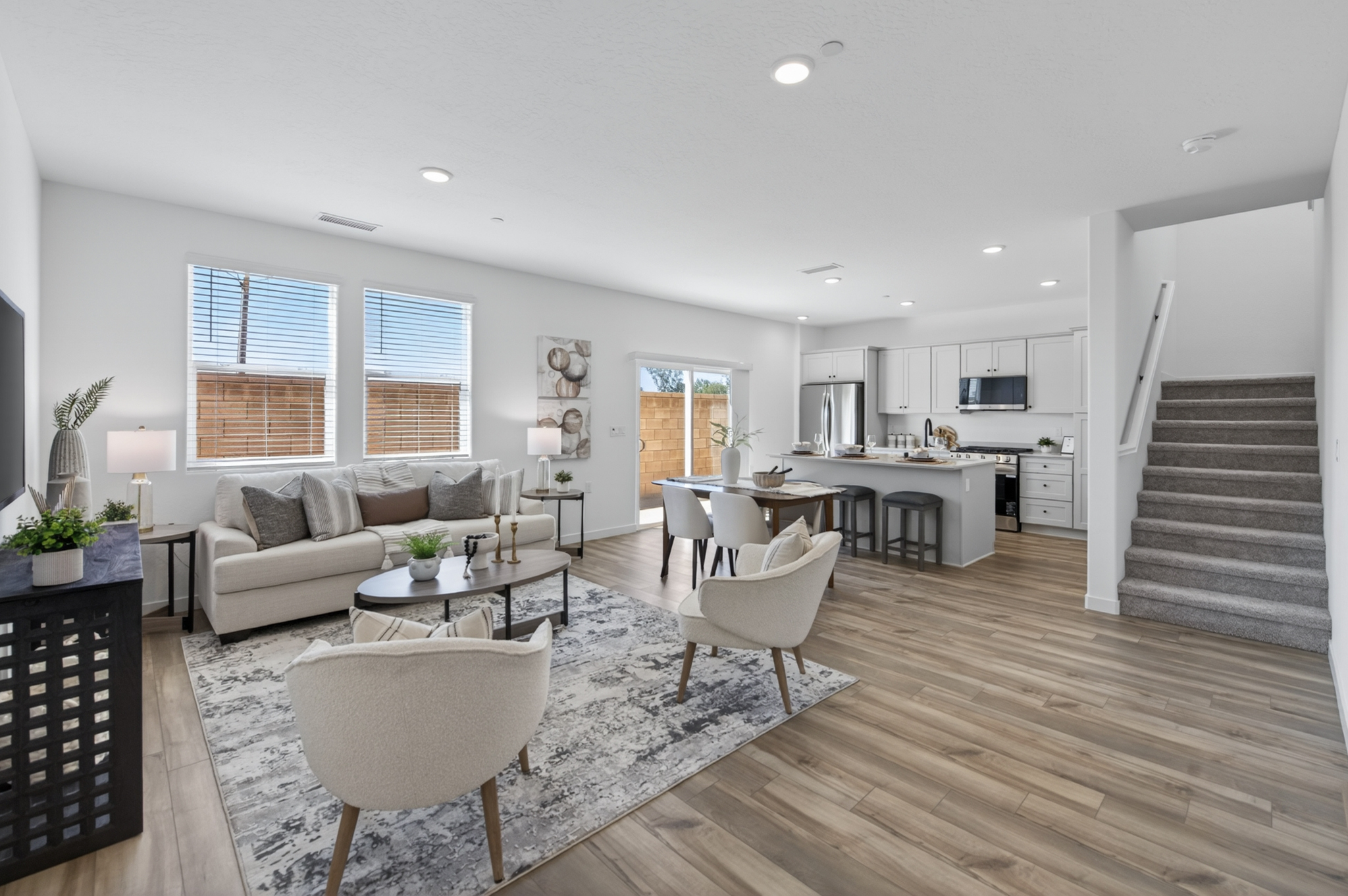 A large living room with a wood floor and white furniture.