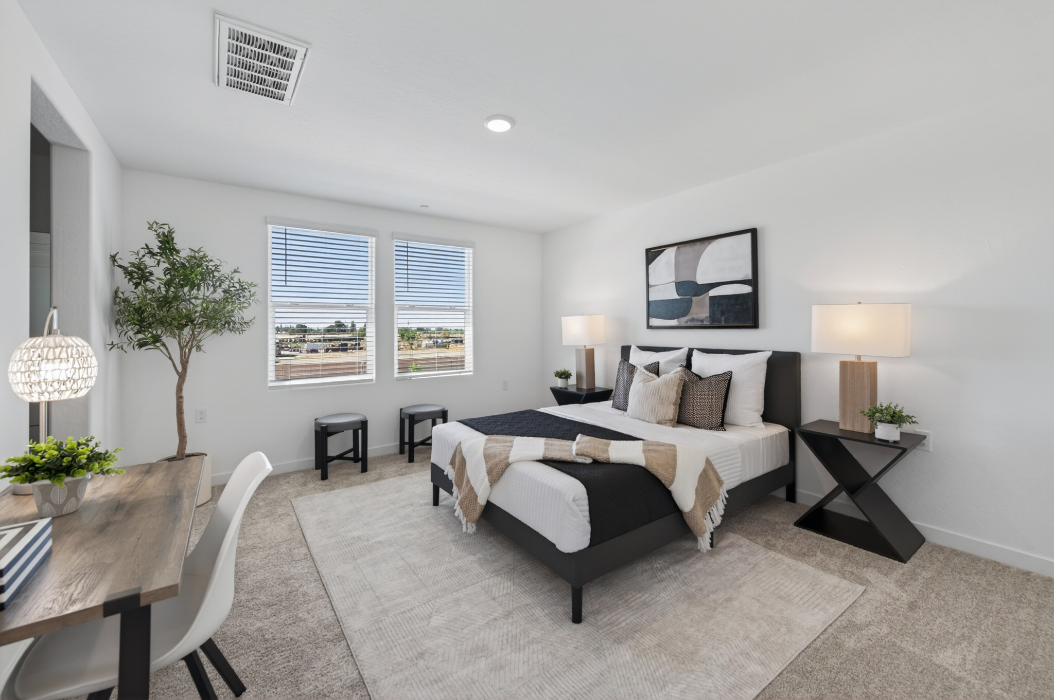 A bedroom with a bed and chairs.