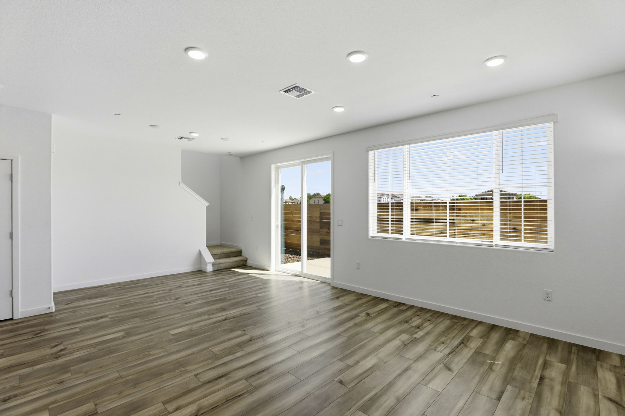 A room with a wood floor and a wood floor with a window.
