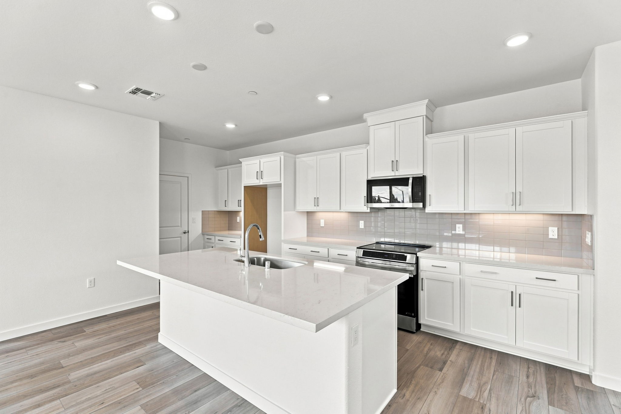 A kitchen with white cabinets.