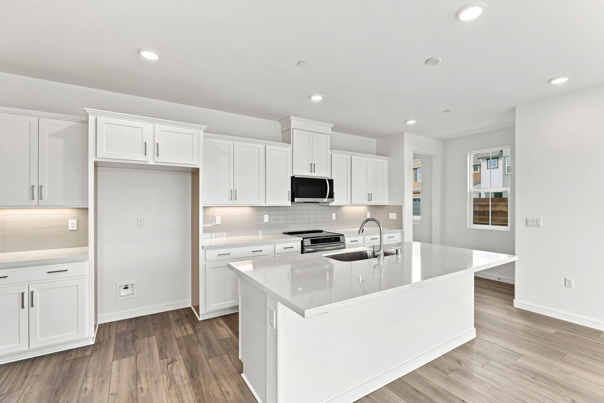 A kitchen with white cabinets.