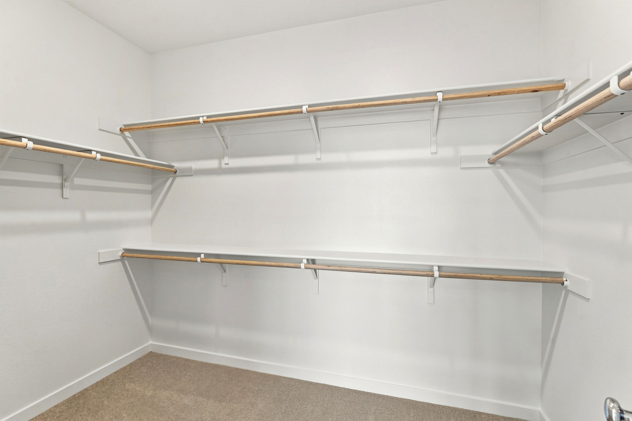 A white wall with a metal bar.