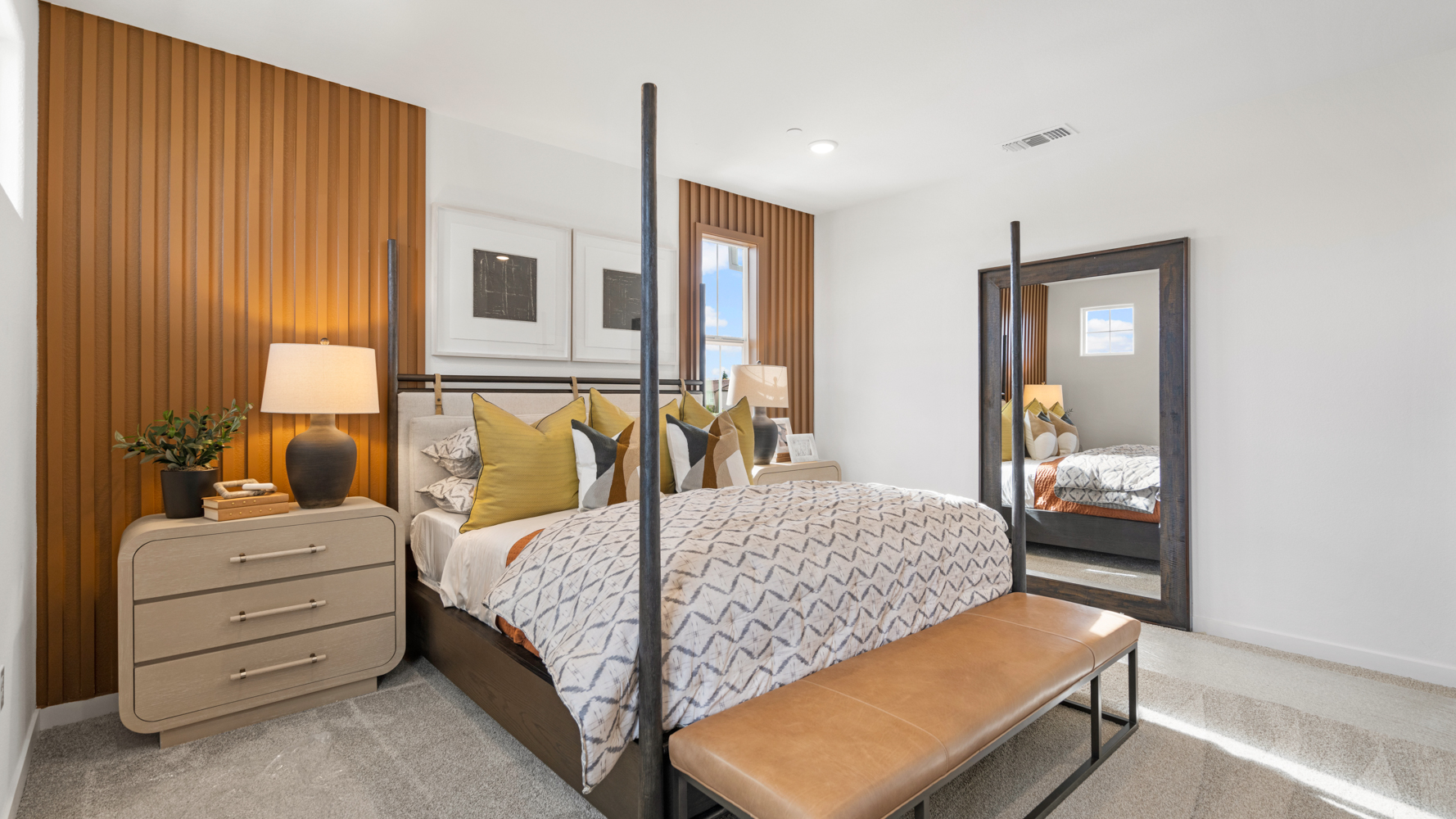 A bedroom with a bed and a bench.