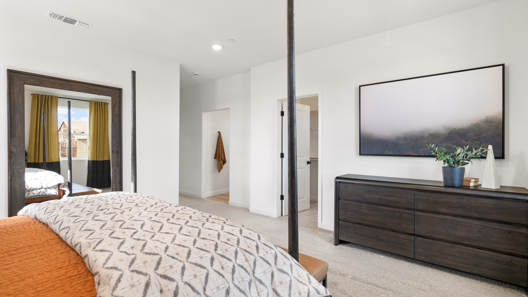 A bedroom with a bed and a dresser.