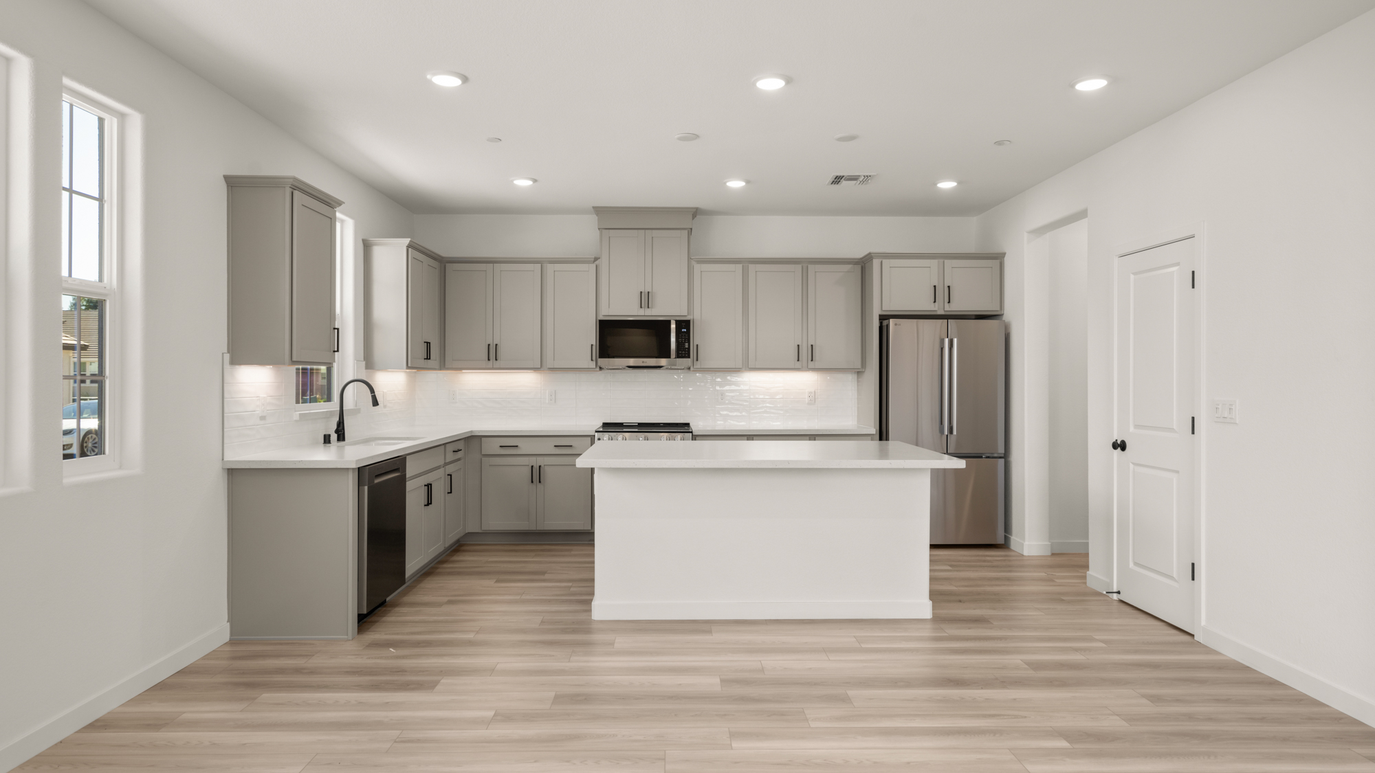 A kitchen with white cabinets.