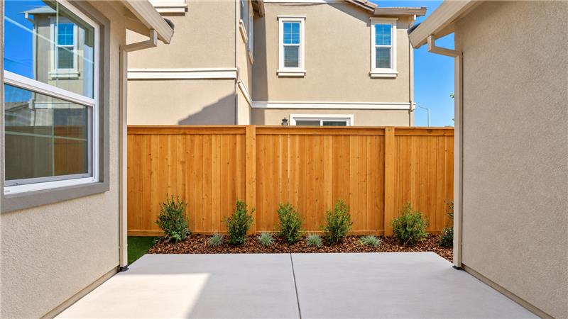 A fenced in yard with a building in the background.