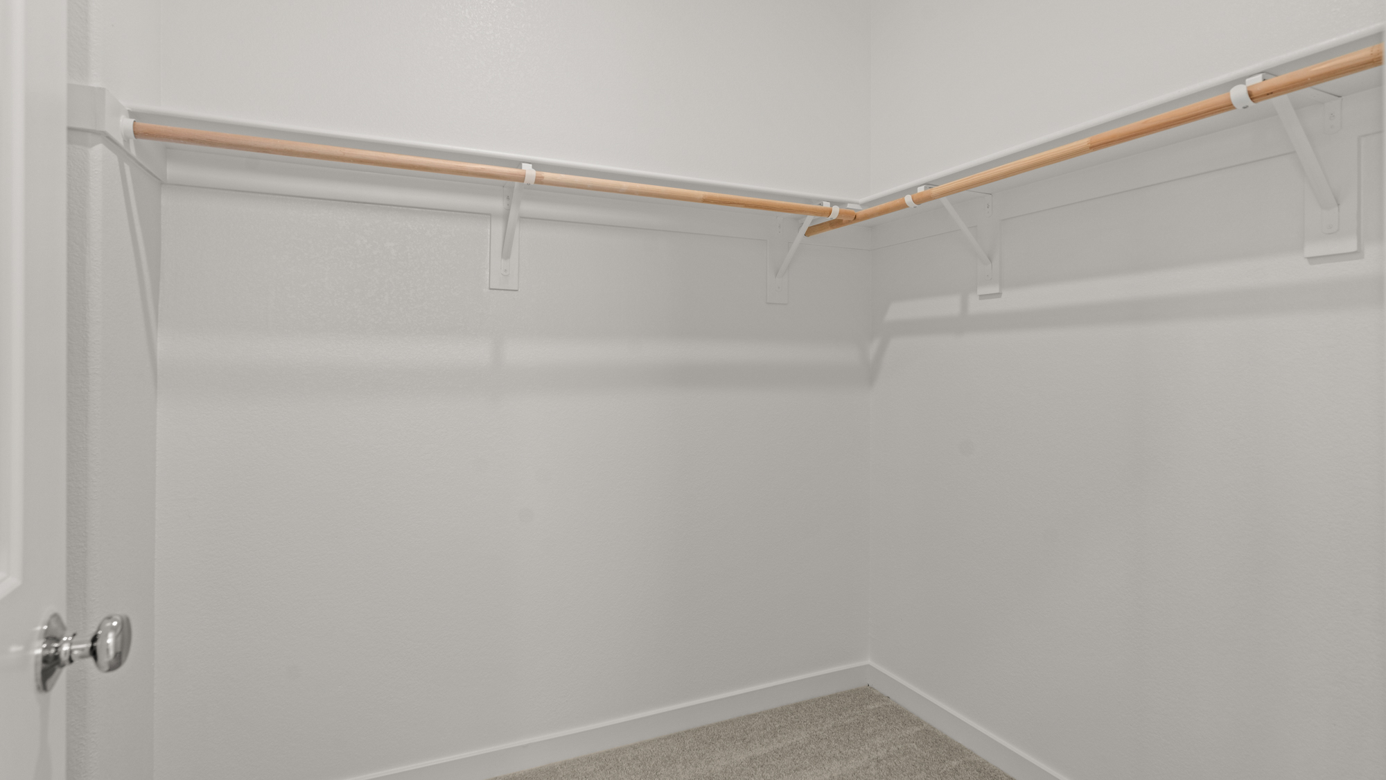 A white wall with a metal bar.