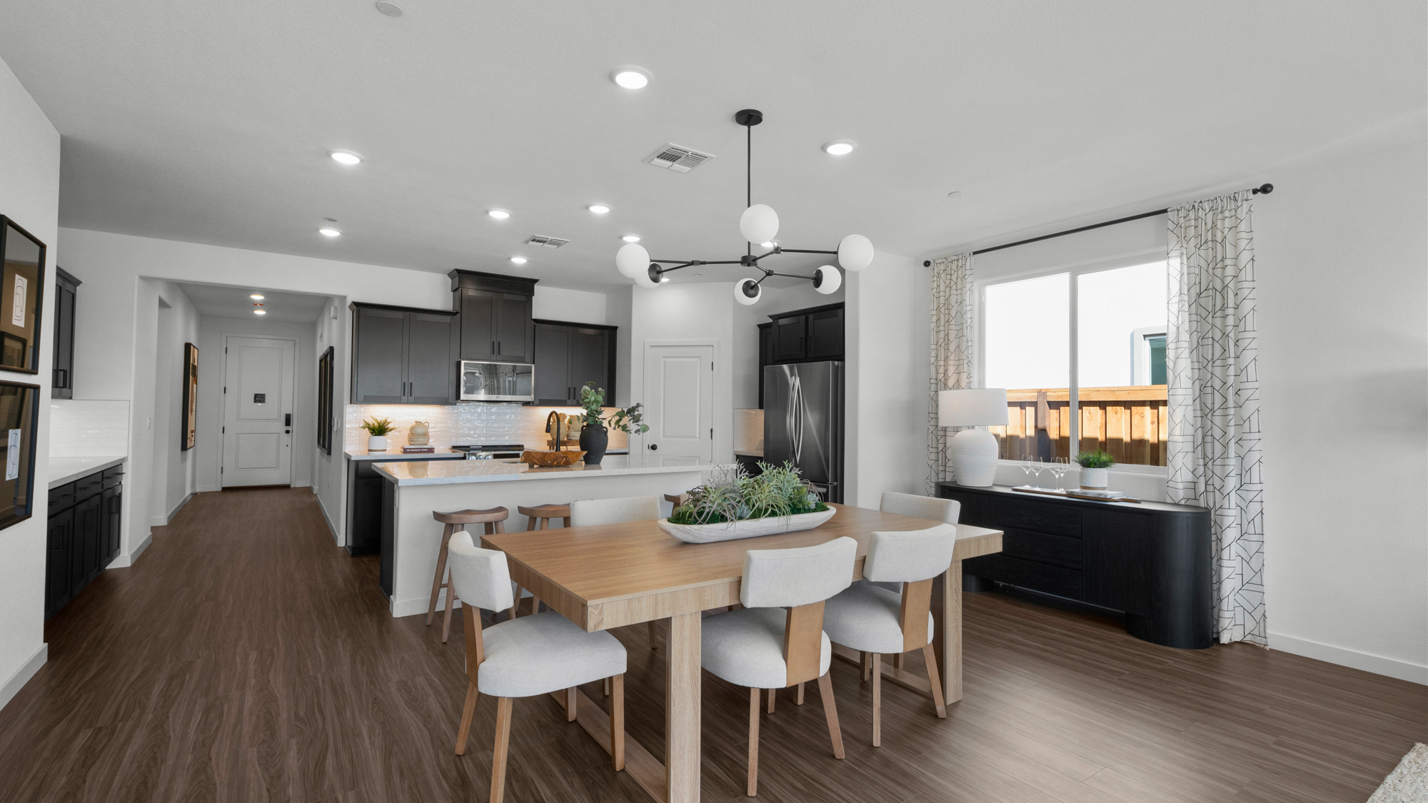 A kitchen with a dining table and chairs.