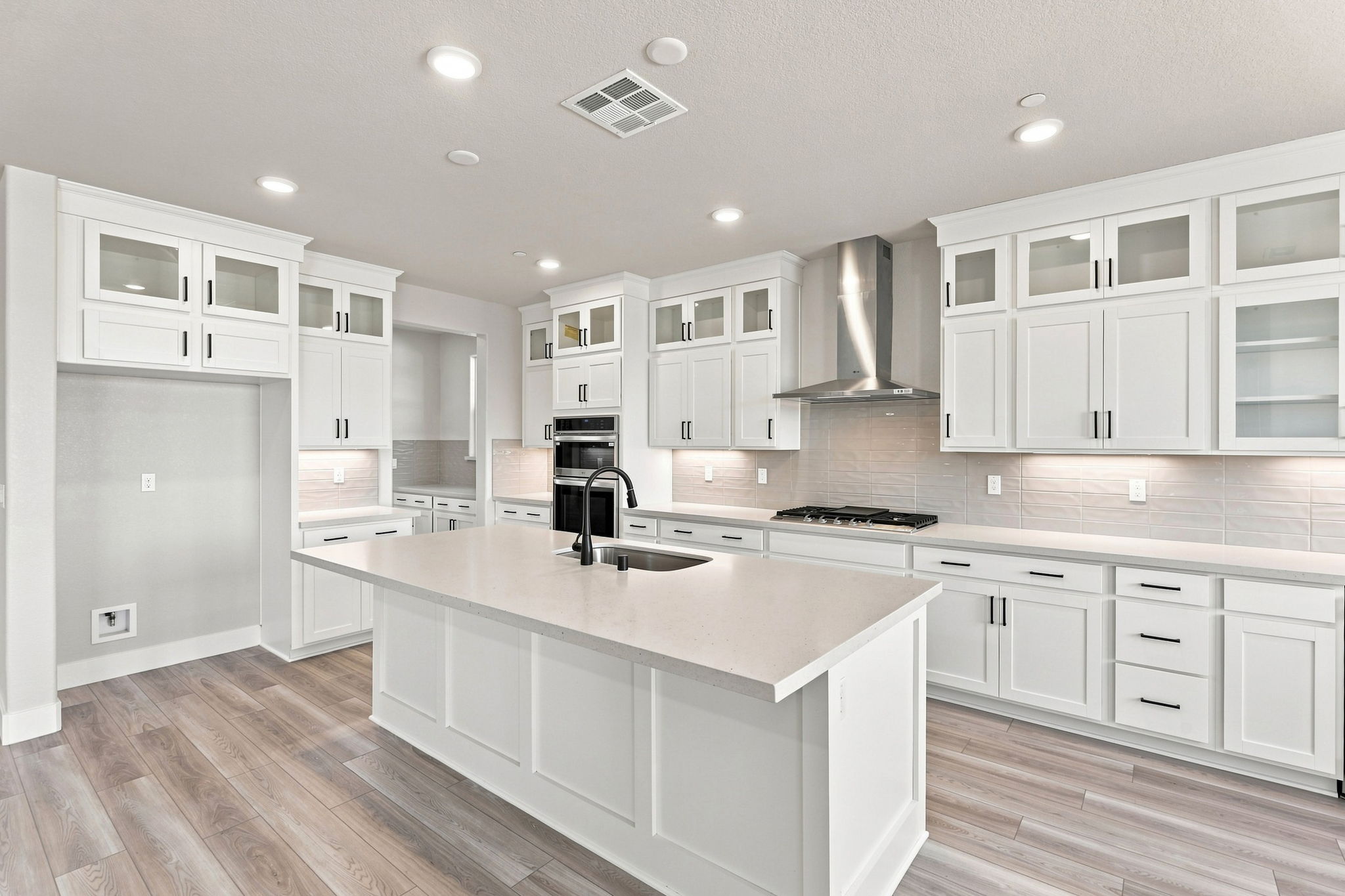 A kitchen with white cabinets.