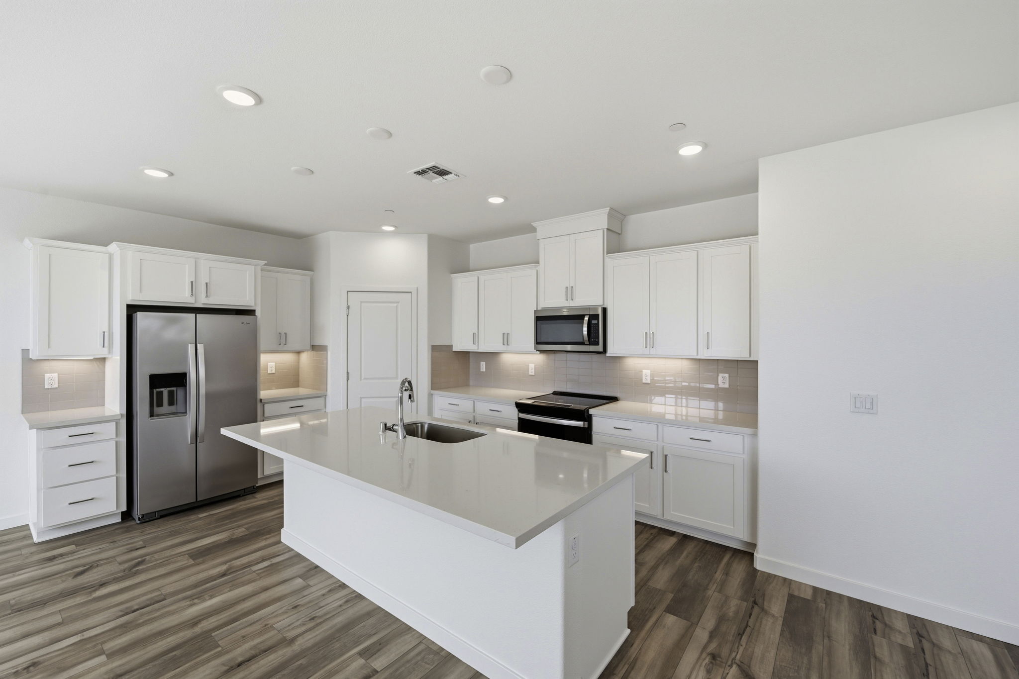 A kitchen with white cabinets.