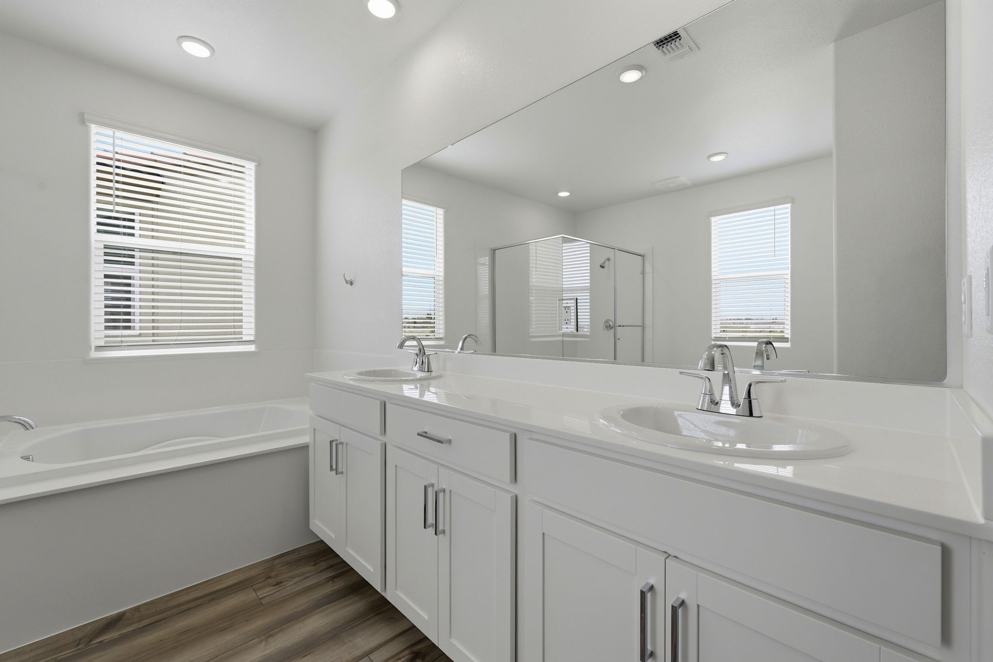 A bathroom with a tub sink and mirror.