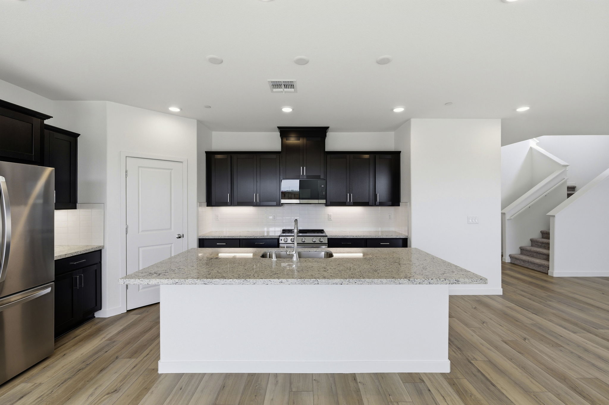 A kitchen with black cabinets.