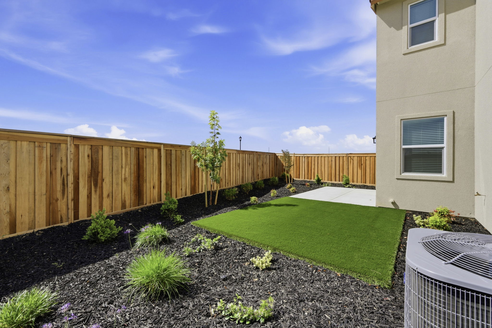 A backyard with a fence and a yard.
