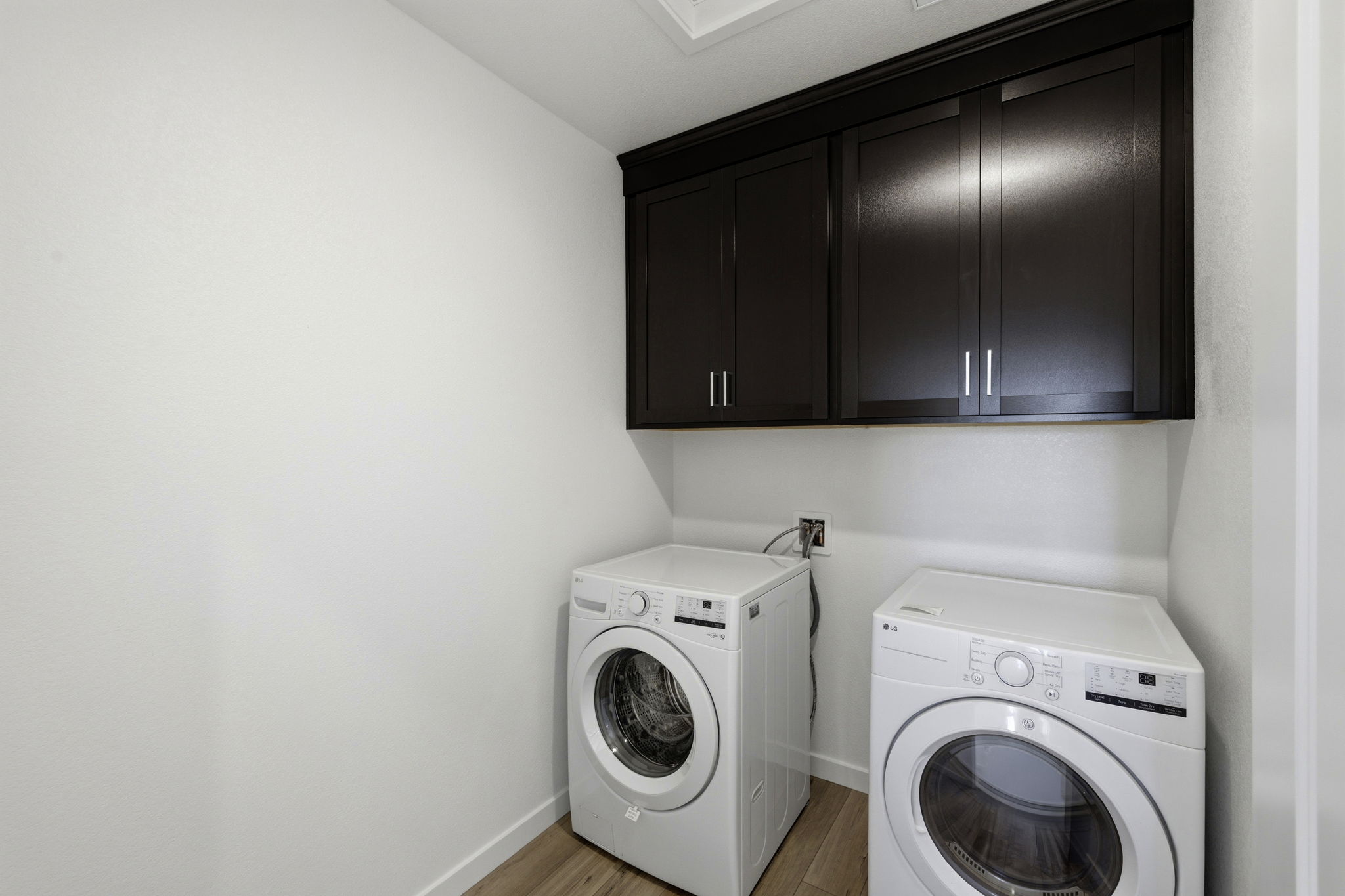 A room with a washing machine and a dryer.