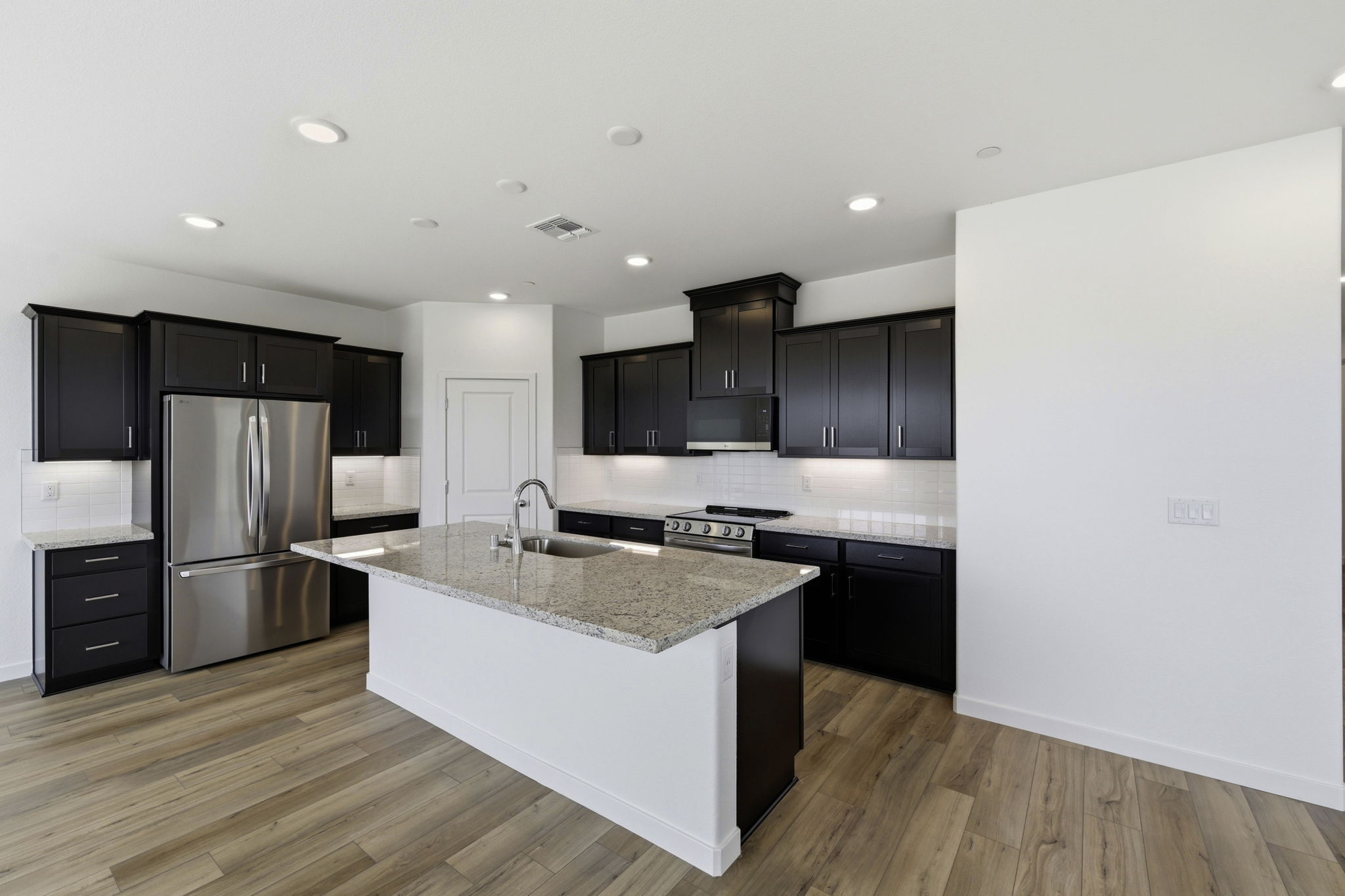 A kitchen with black cabinets.