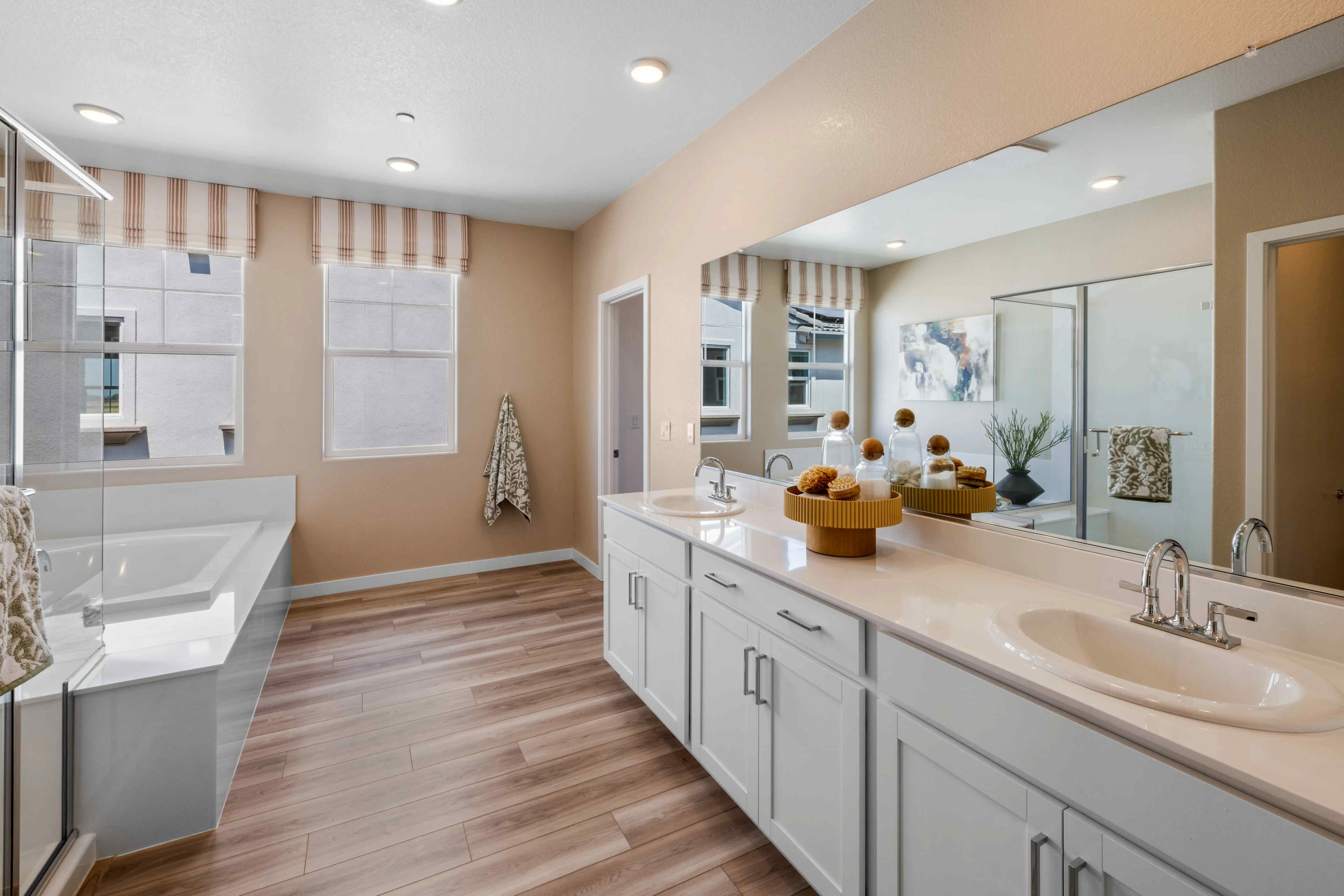 A bathroom with a tub sink and a large mirror.