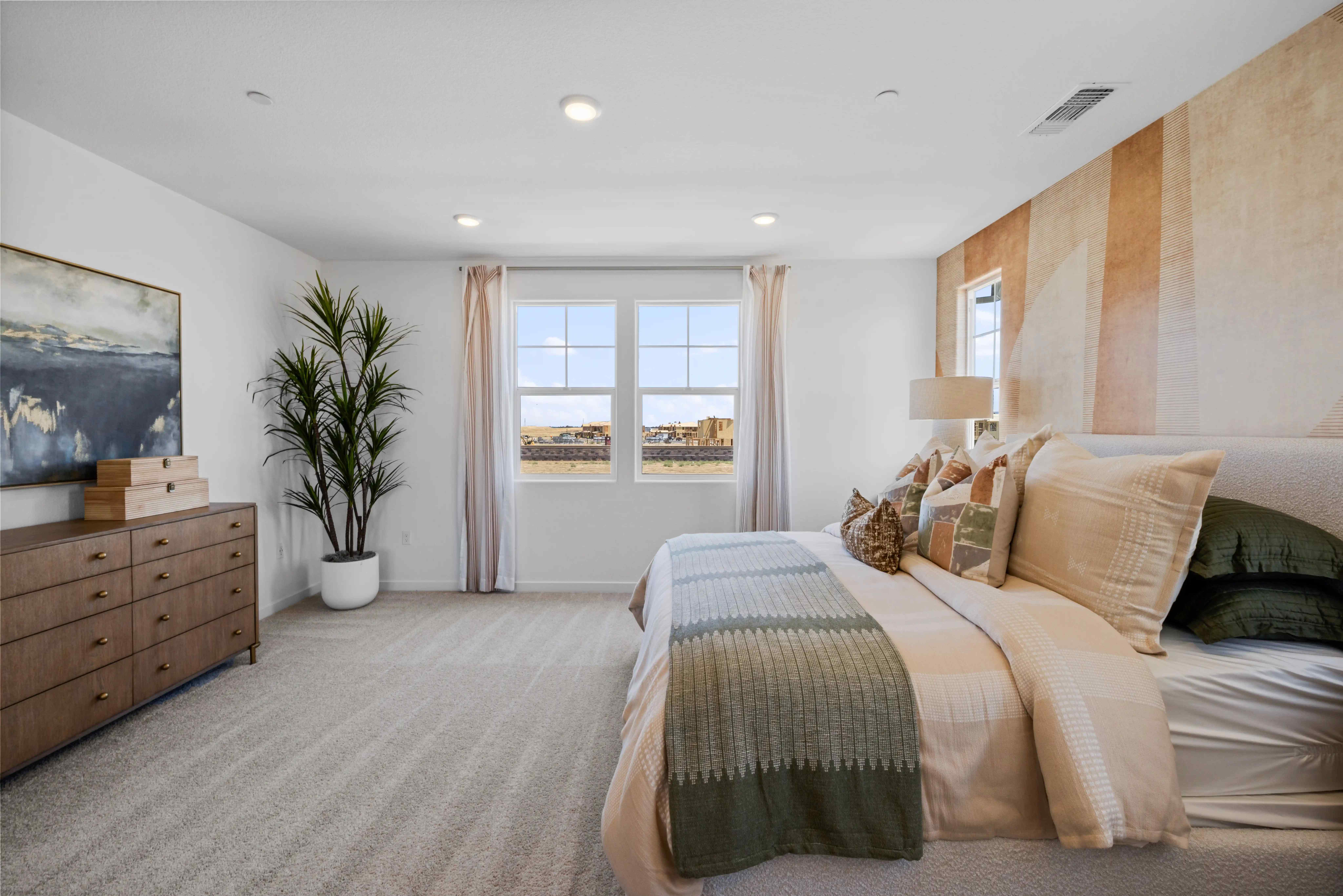 A bedroom with a bed and a plant.