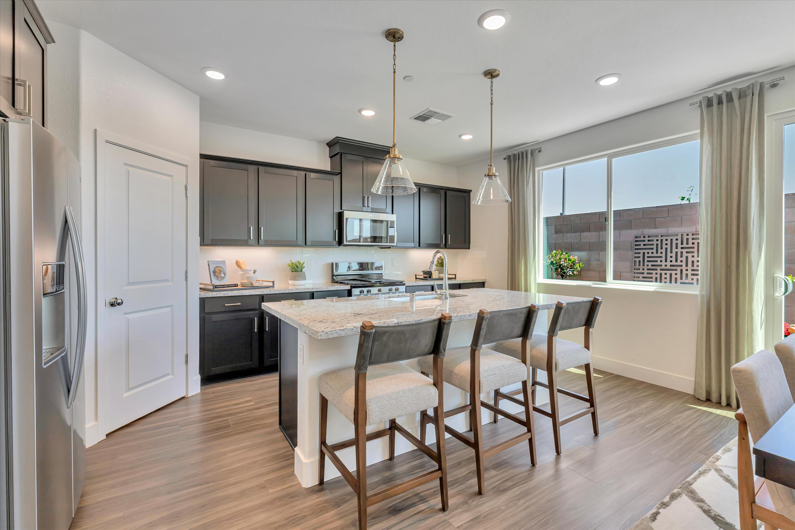 A kitchen with a dining table and chairs.