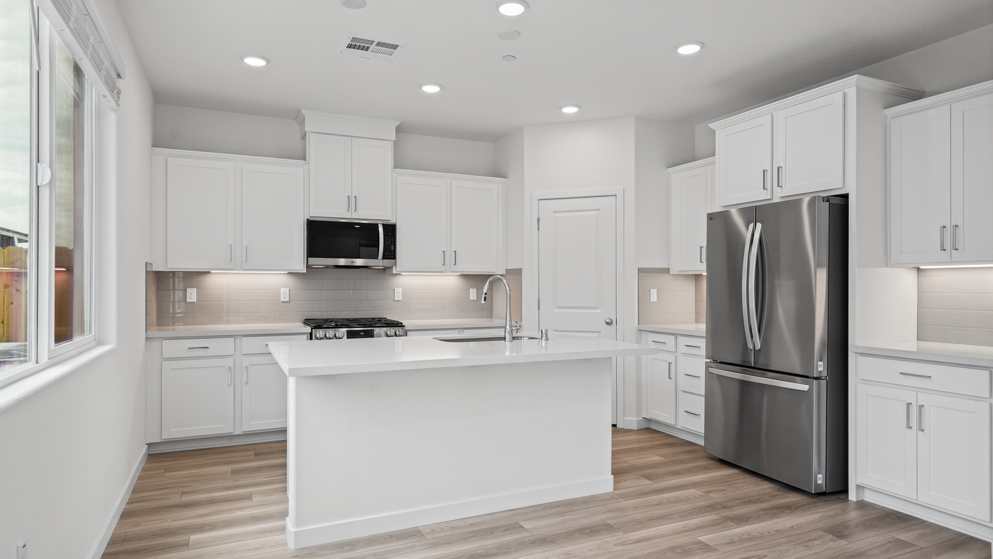 A kitchen with white cabinets.