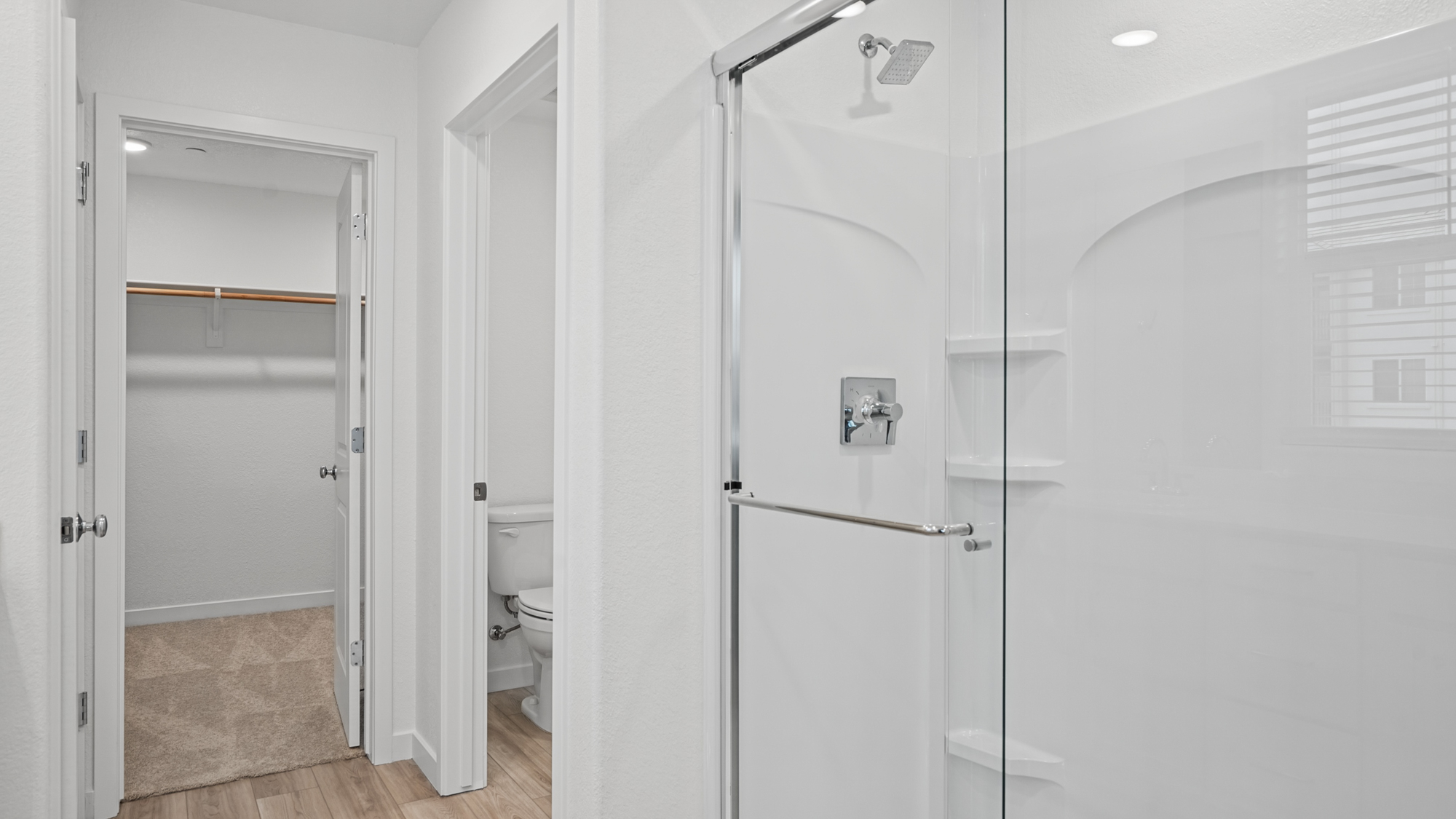 A bathroom with a shower unit and toilet.