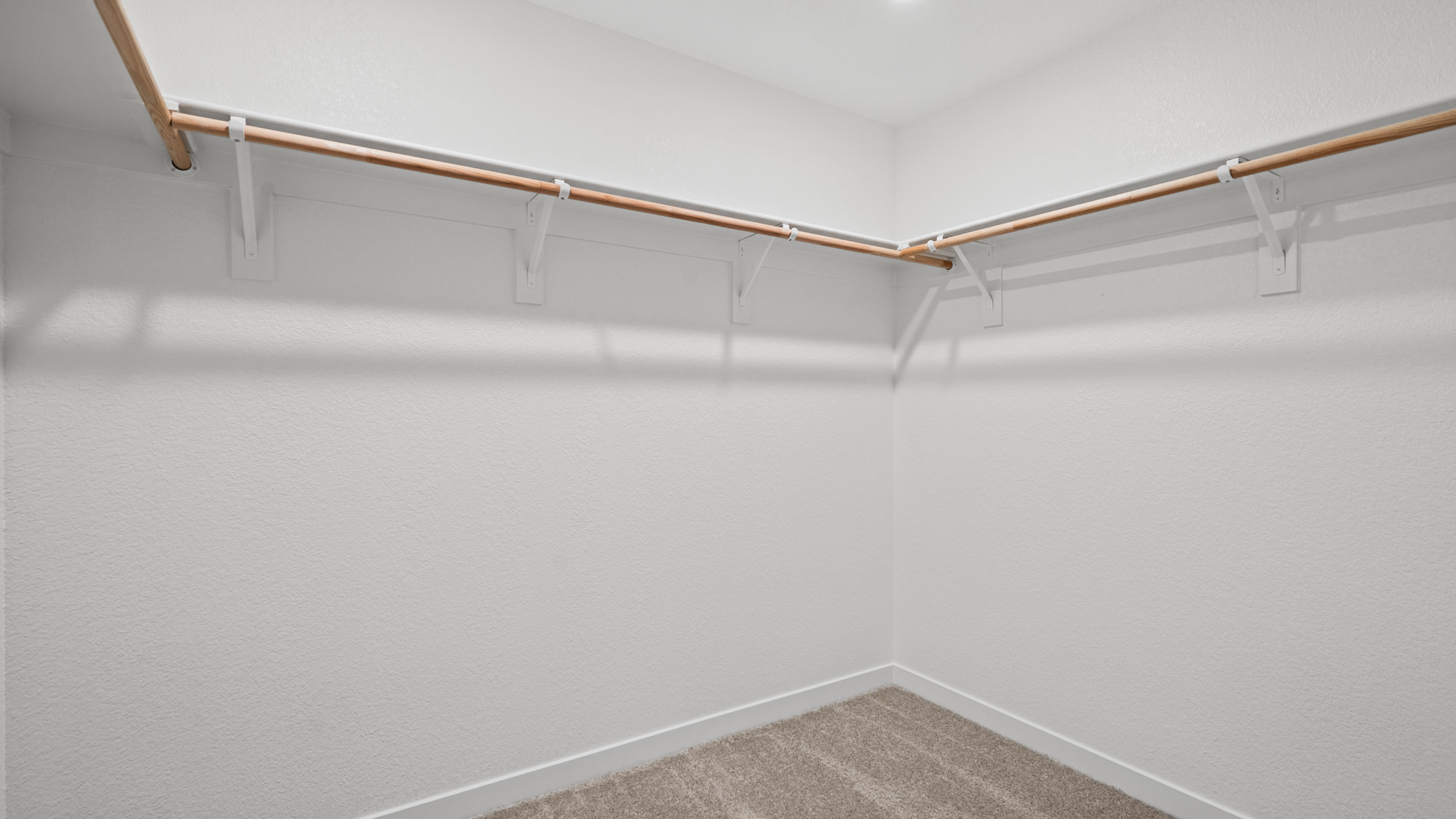 A white wall with a metal bar.