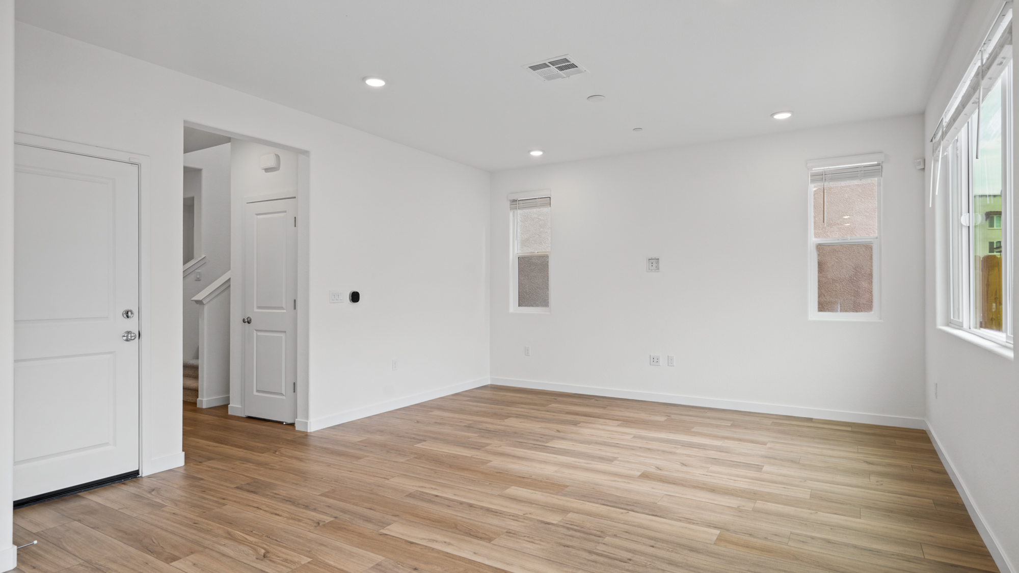 A room with white walls and wood floors.