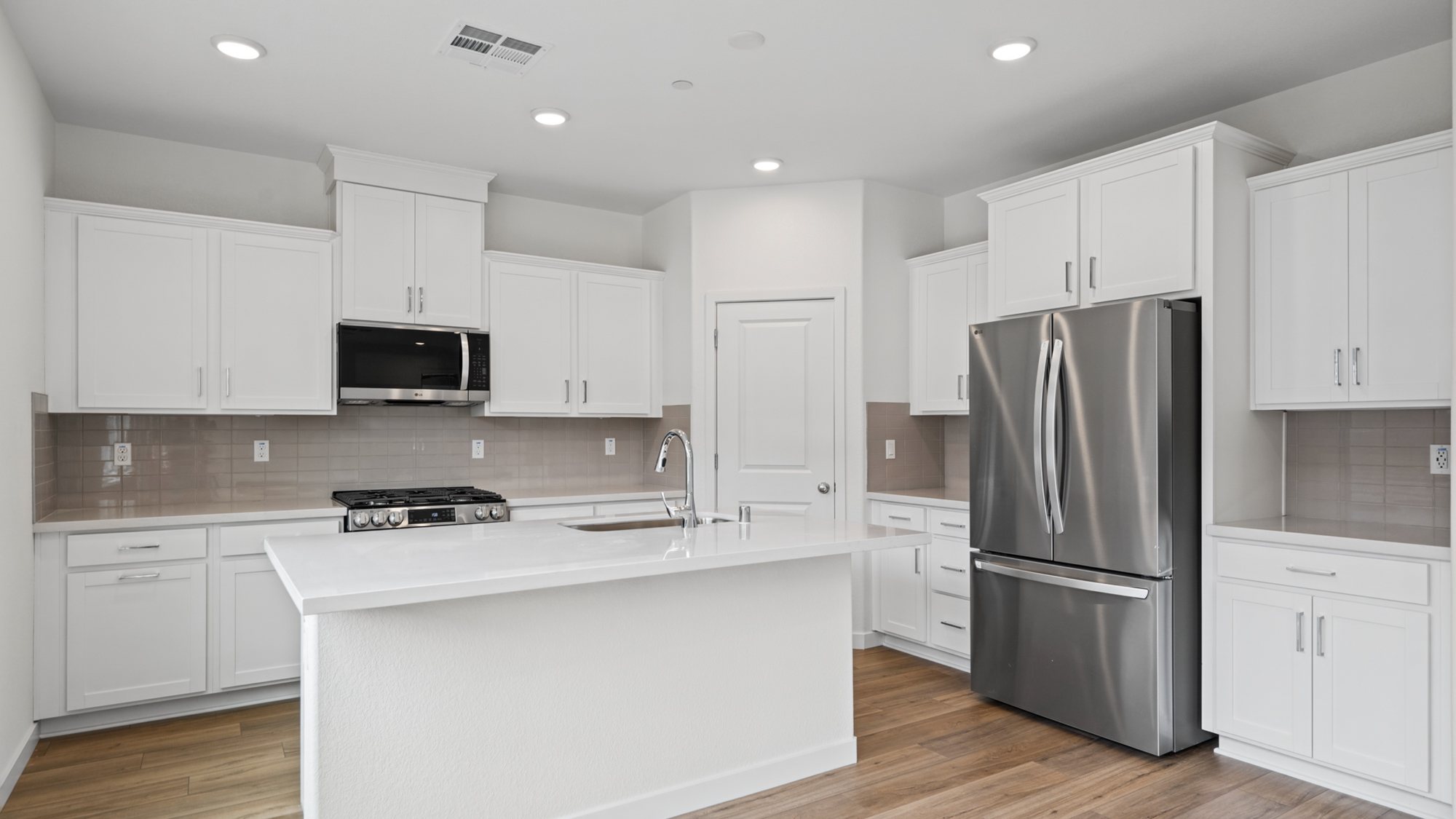 A kitchen with white cabinets.