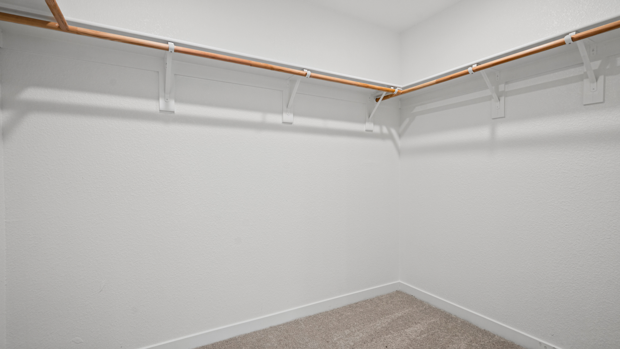 A white wall with a metal bar.