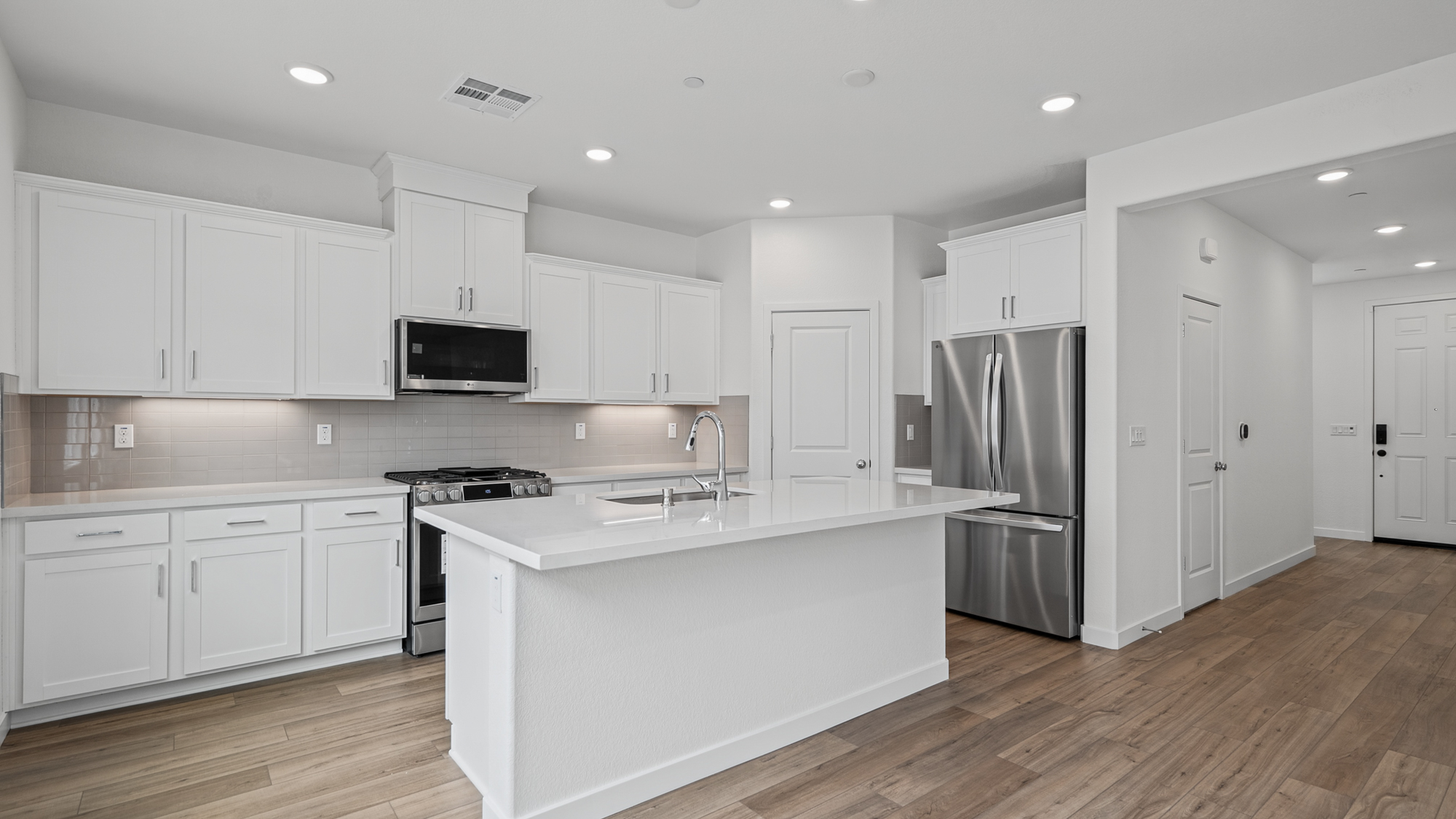 A kitchen with white cabinets.