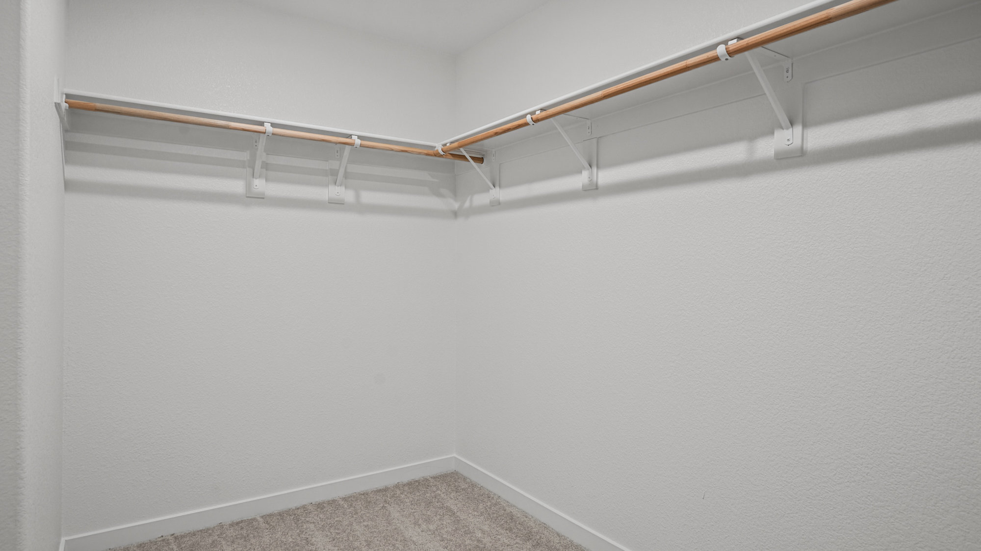 A white wall with a metal bar.