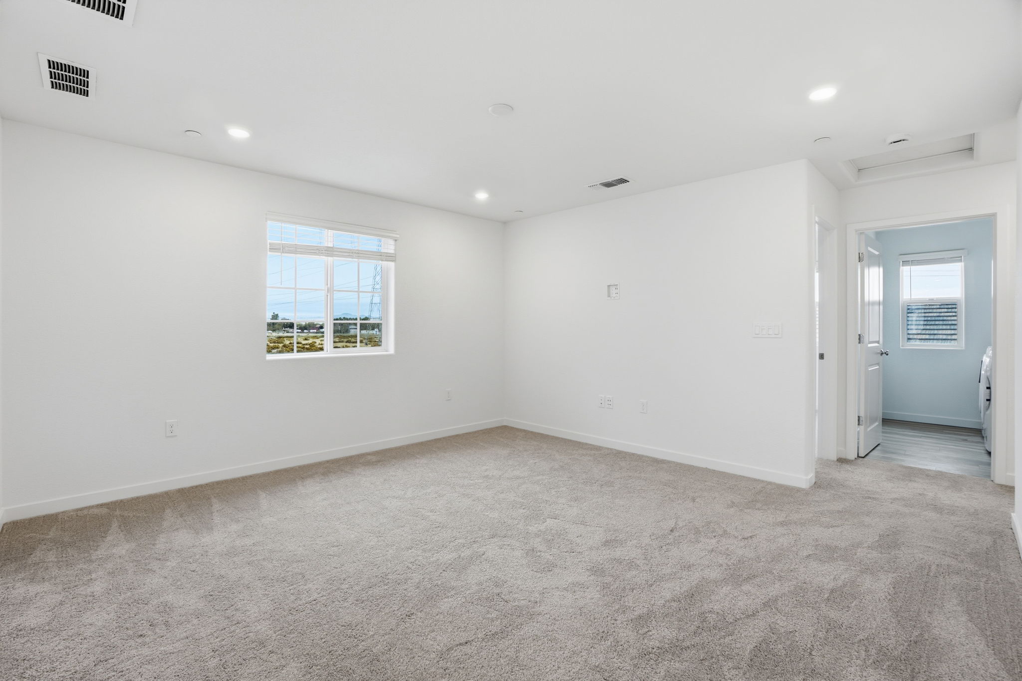 A room with white walls and a window.
