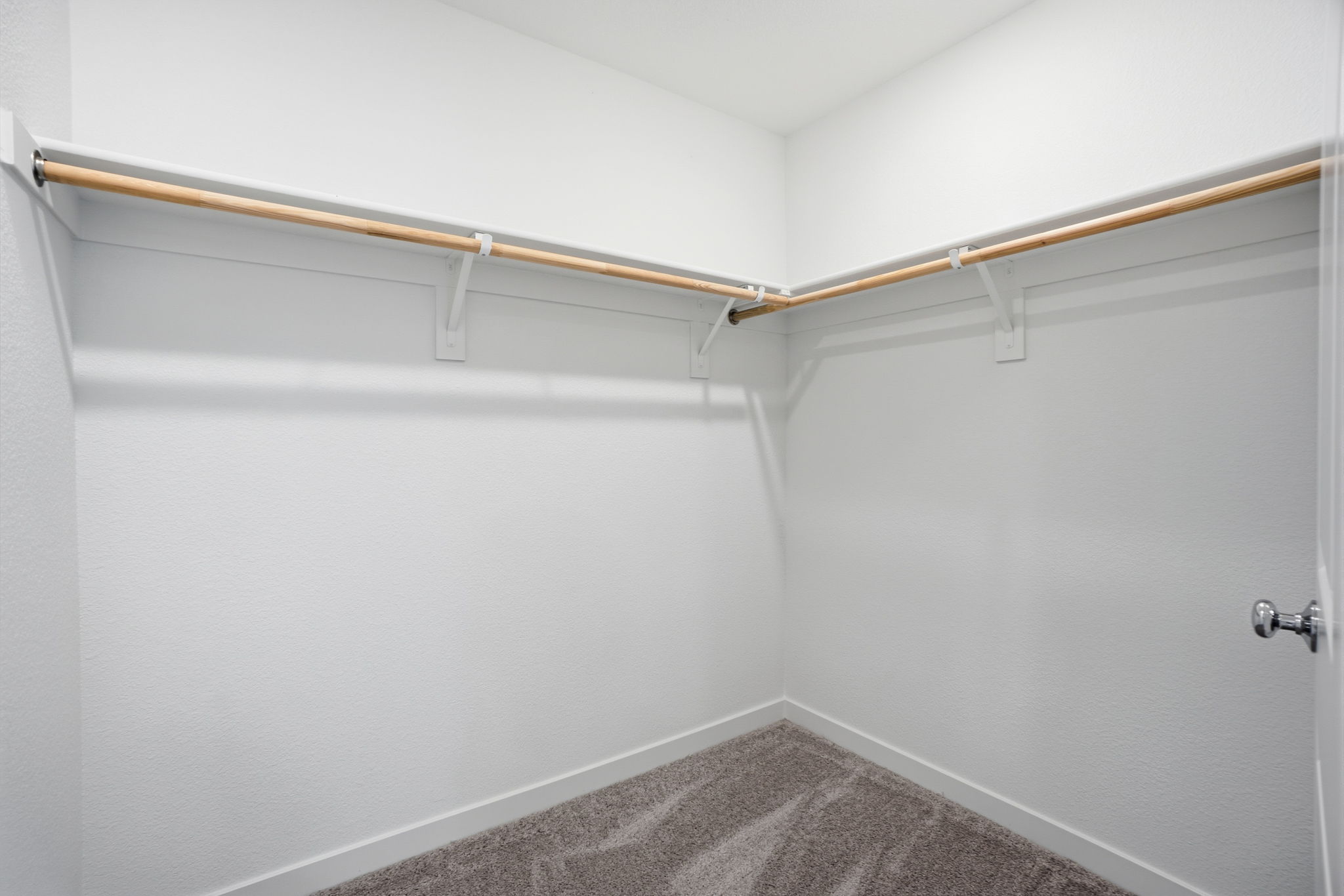 A white wall with a metal bar.
