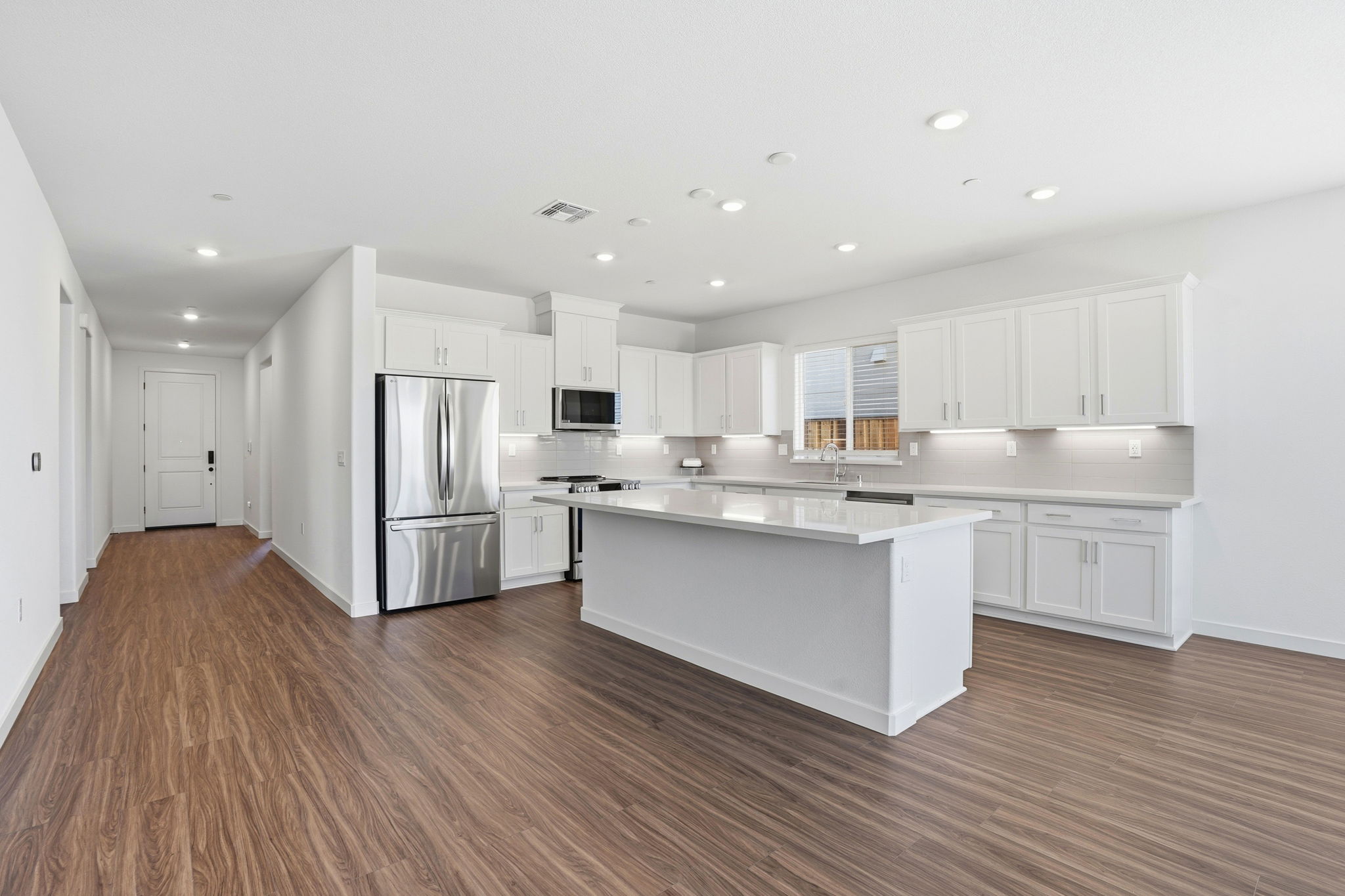 A kitchen with white cabinets.