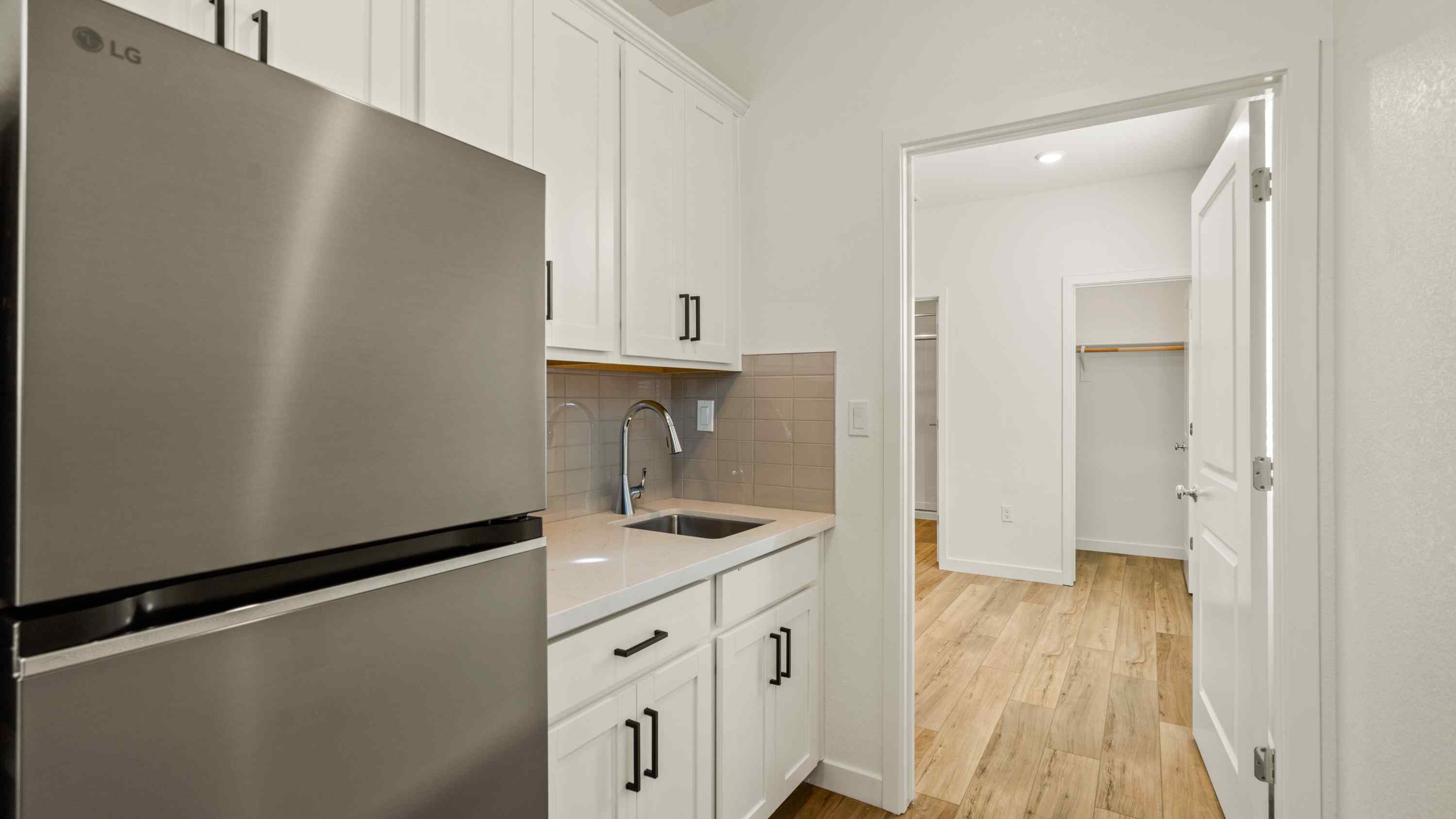A kitchen with white cabinets.