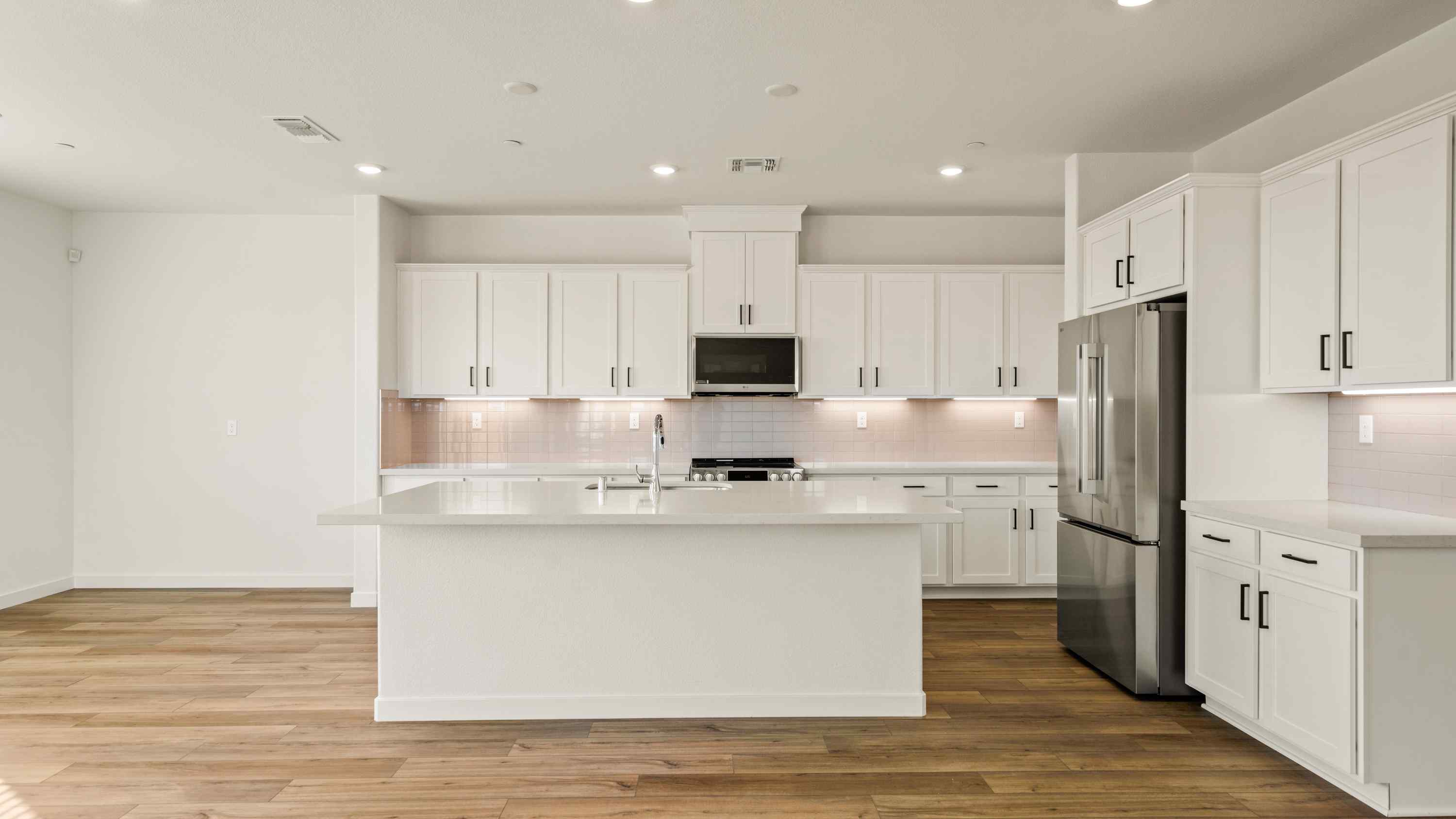 A kitchen with white cabinets.