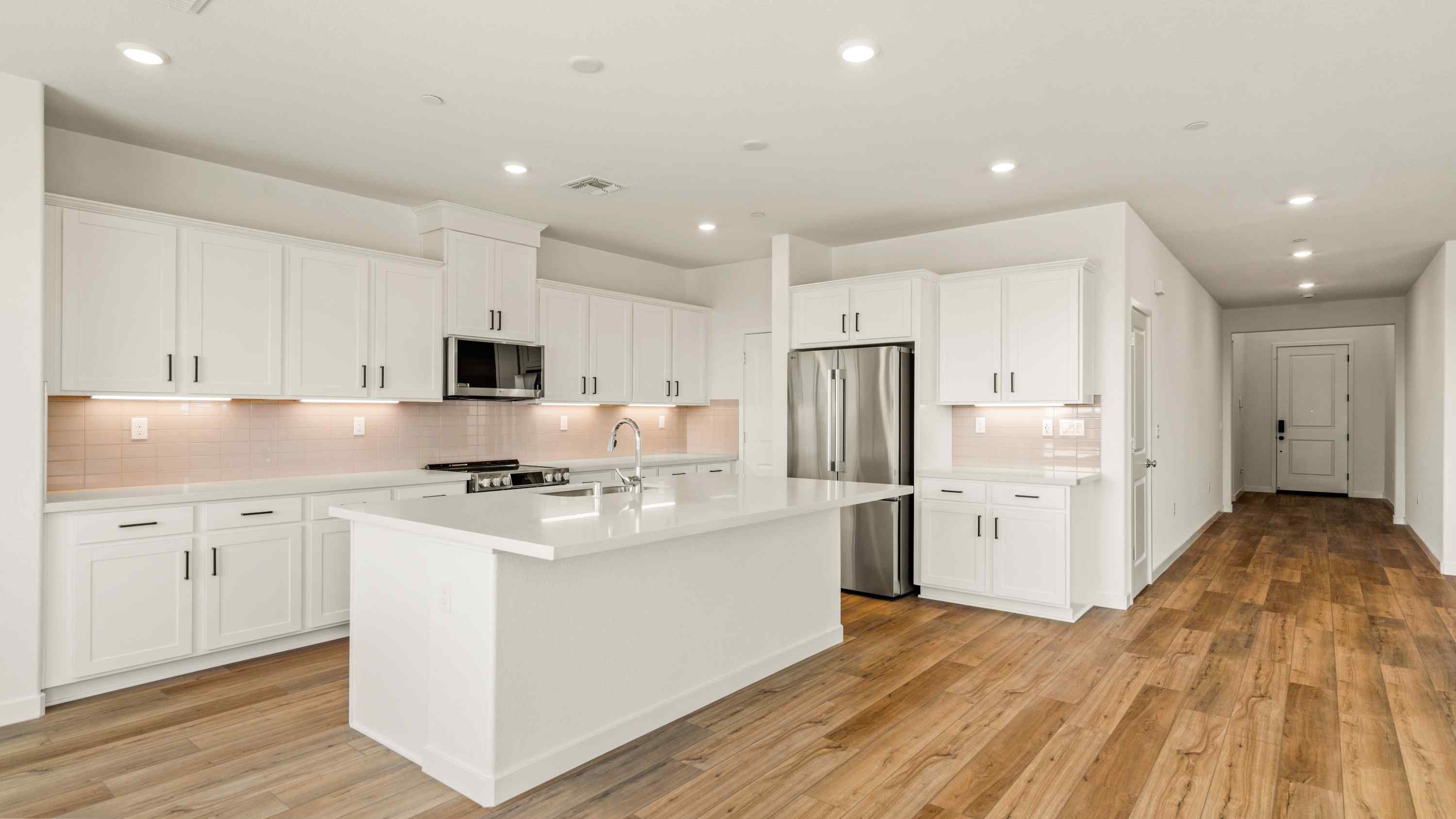 A kitchen with white cabinets.